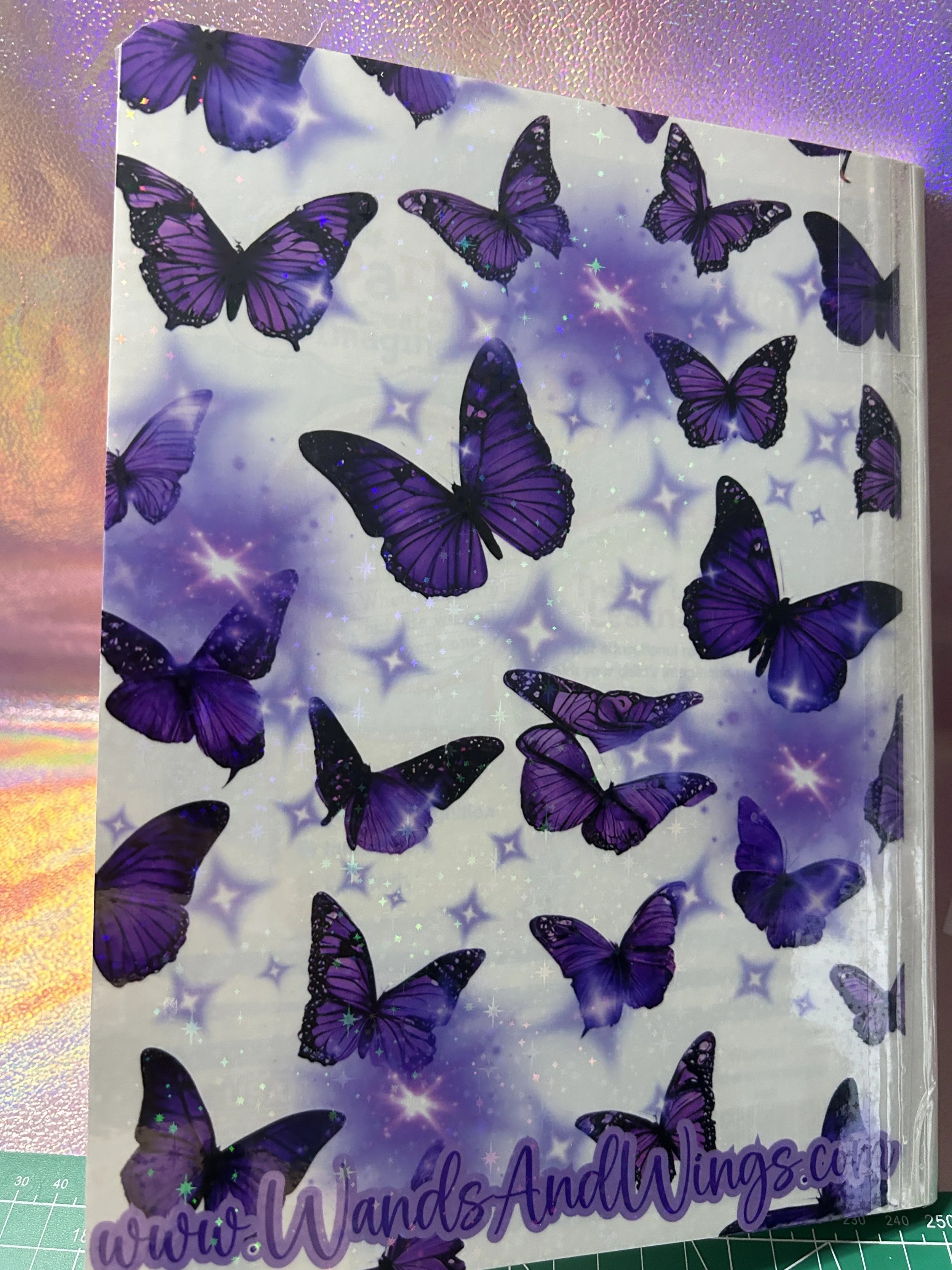 Purple butterflies on a decorative background with stars and a website URL at the bottom.