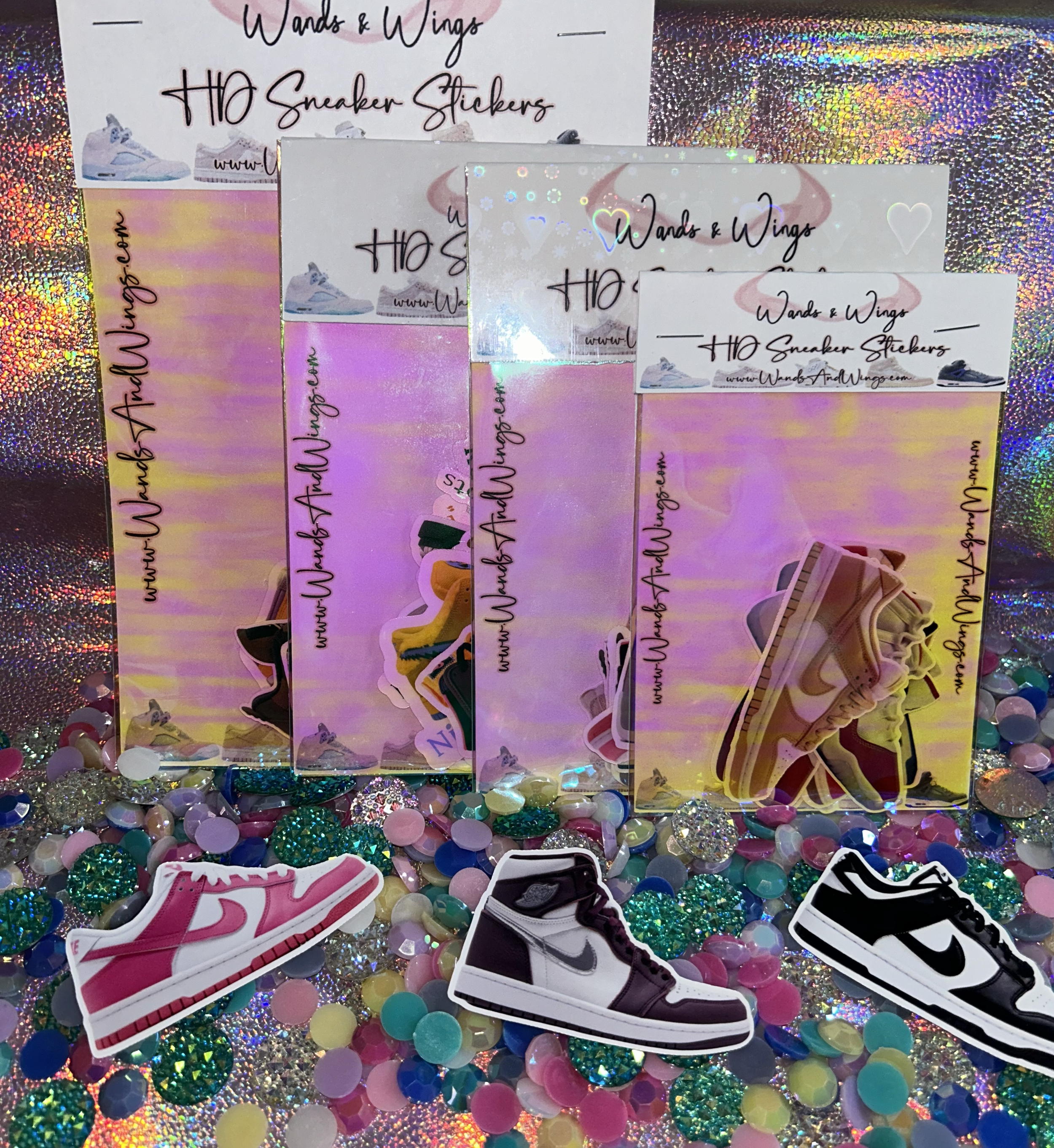 Colorful display of Wands & Wings sneaker stickers in various colors and designs on a sparkly background with scattered shiny discs.