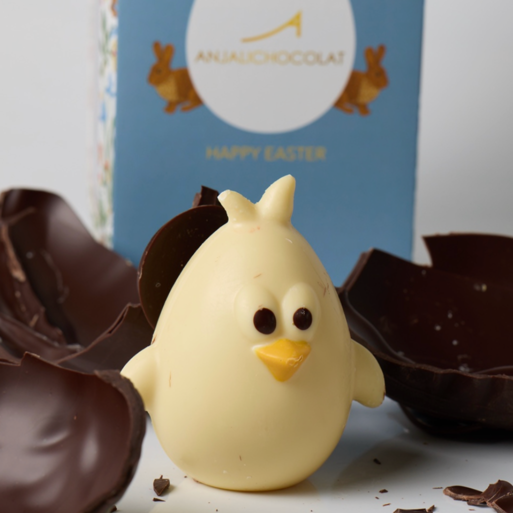 Easter Egg Surprise reveal: a White chocolate chick with small black eyes and a yellow beak, inside our 70% dark artisan chocolate easter egg by anjalichocolat