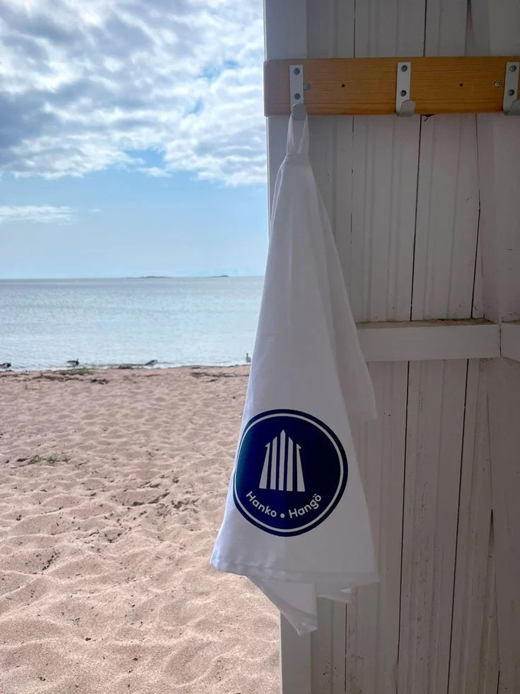Keittiopyyhe Hanko-logolla. Hanko-tuotteille lgo- ja merkkisuunnittelua . Hanko-lippis on myynnissä Tian Veranta -butiikissa, Hangossa.