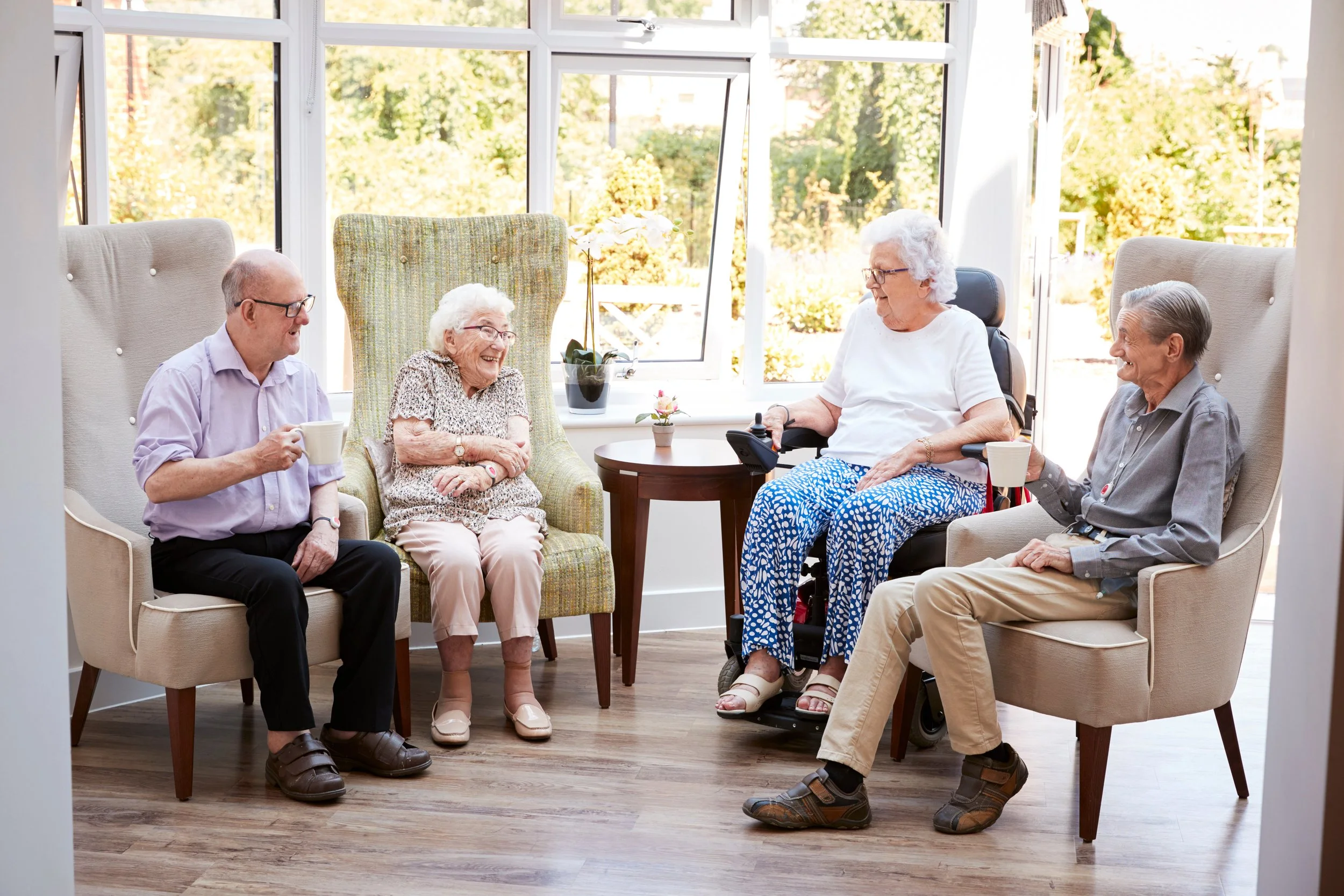 Lovely group of seniors at a nursing home or retirement village smiling and talking with each other