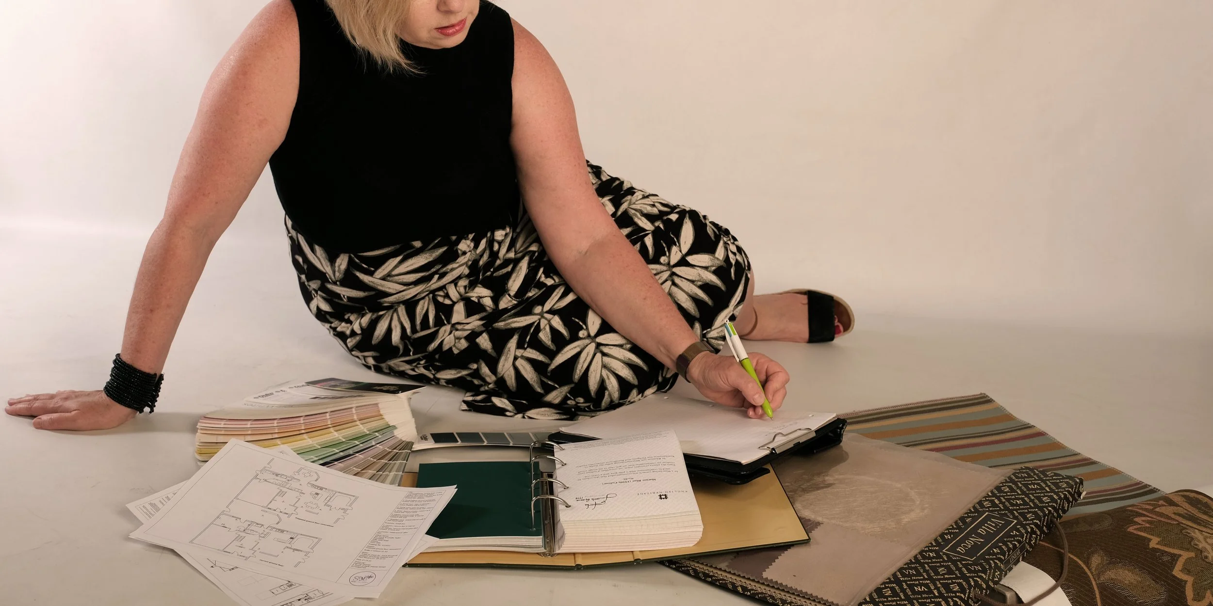 Interior designer Chantal Thomas working with plans and material samples for a full interior design project.