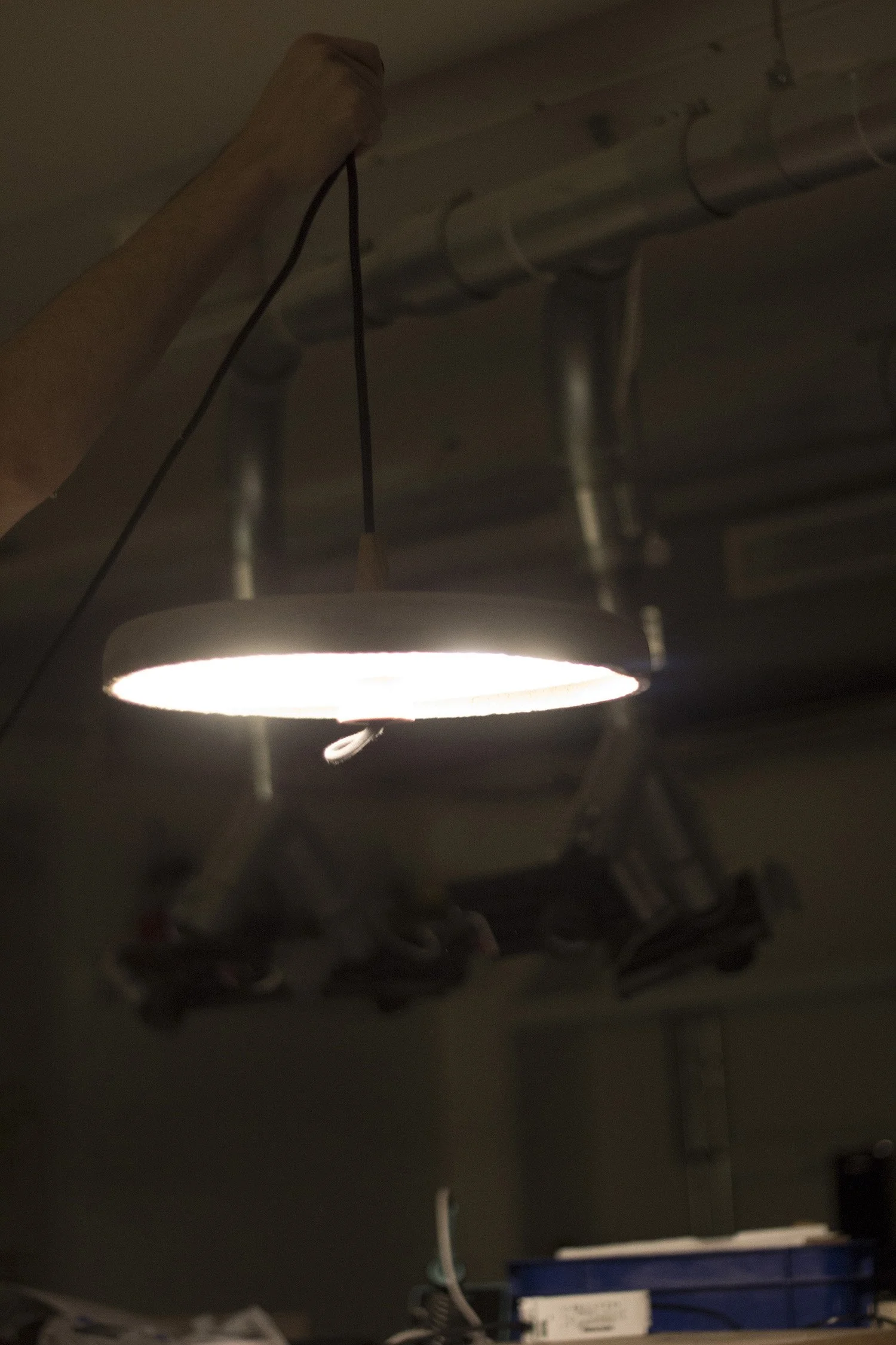 Detailed view of the concrete texture and wood grain in the Origen experimental lamp collection.