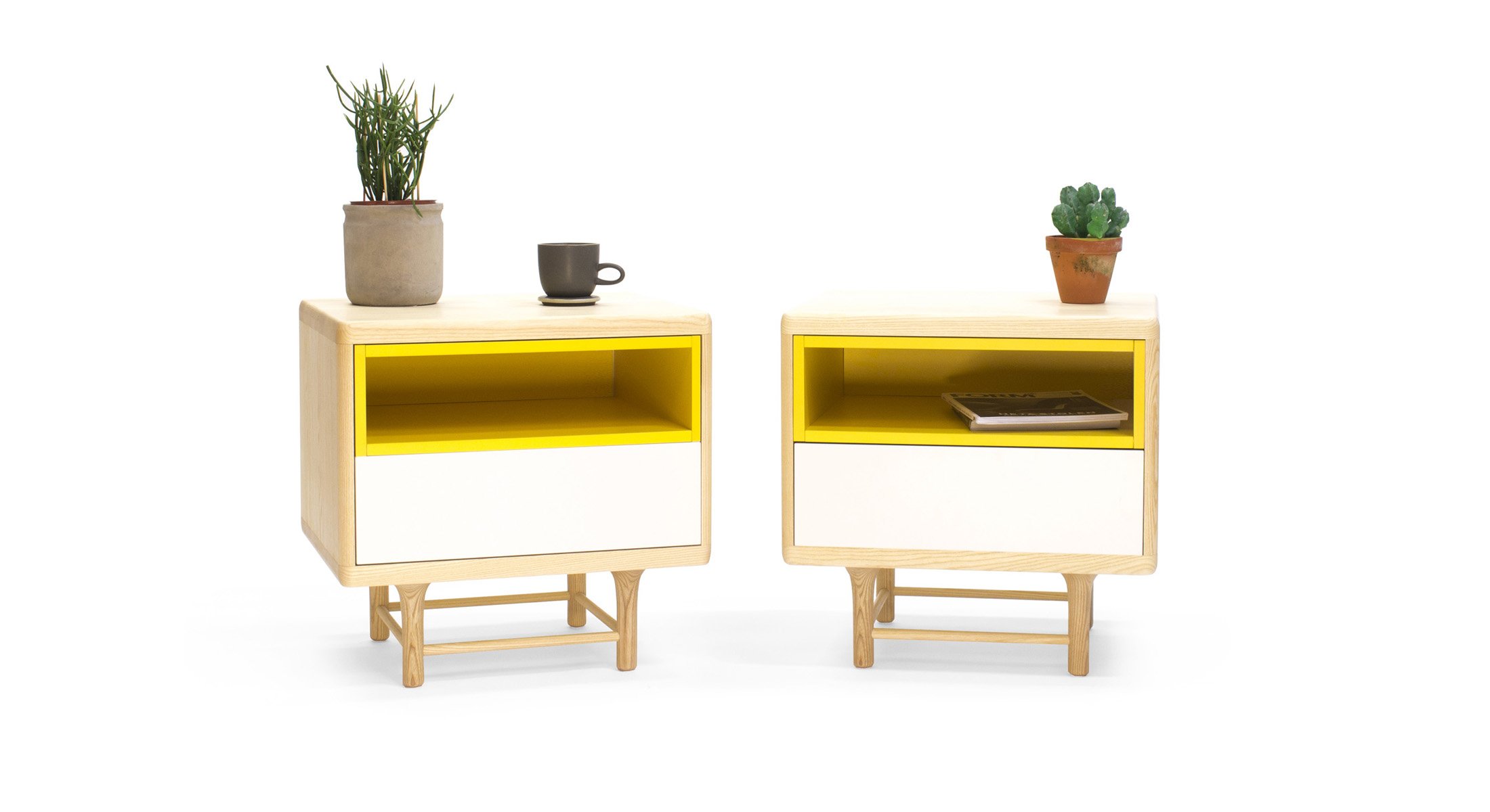 Pareja de mesitas de noche Kaaja con estructura de madera clara y una combinación de módulos internos en amarillo y blanco.
