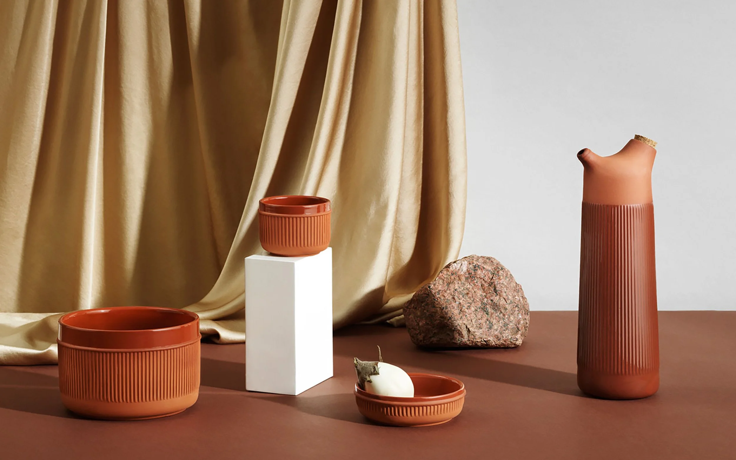 Primer plano de la jarra de terracota destacando el contraste táctil entre las superficies estriadas y el acabado mate.