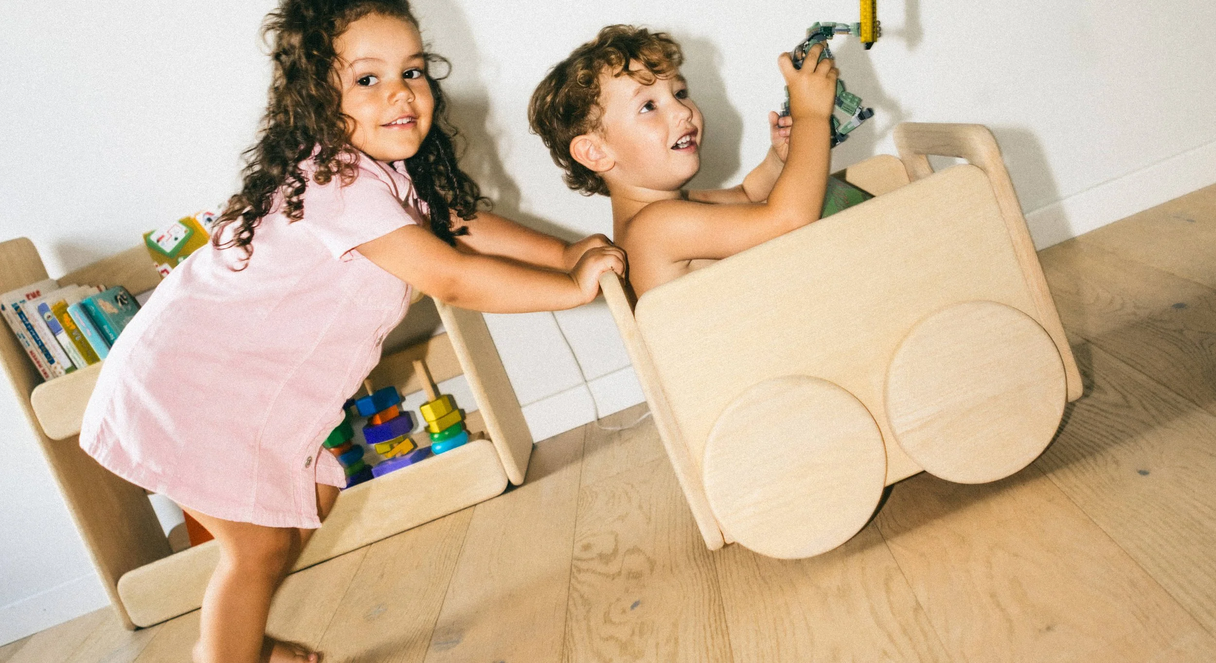 Children playing with the Olaki storage trolley, showcasing its mobile design and soft rounded edges for a safe home environment.
