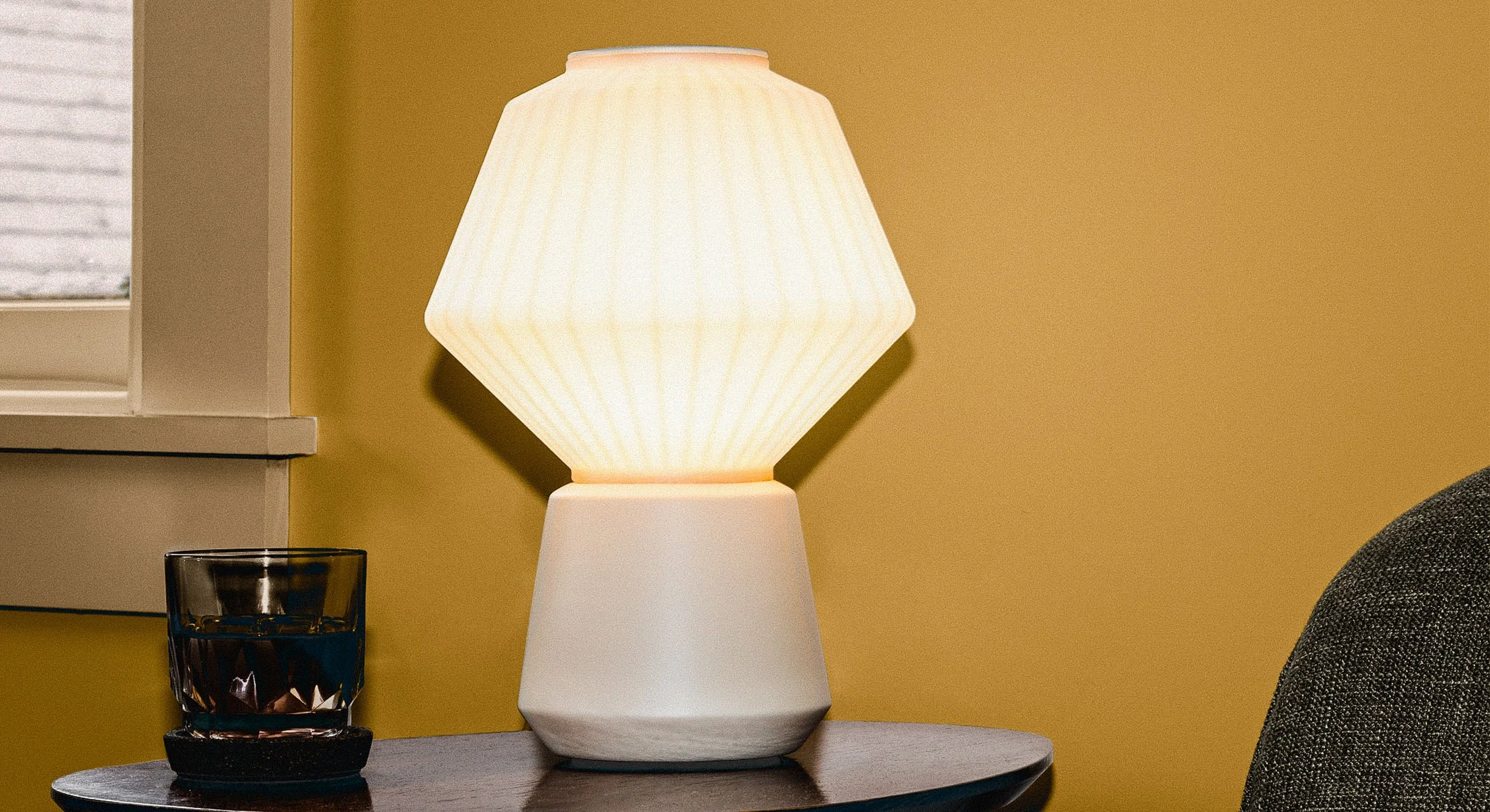 Lámpara de mesa de la colección Granada en un entorno residencial, destacando su carácter escultórico y su estética minimalista.