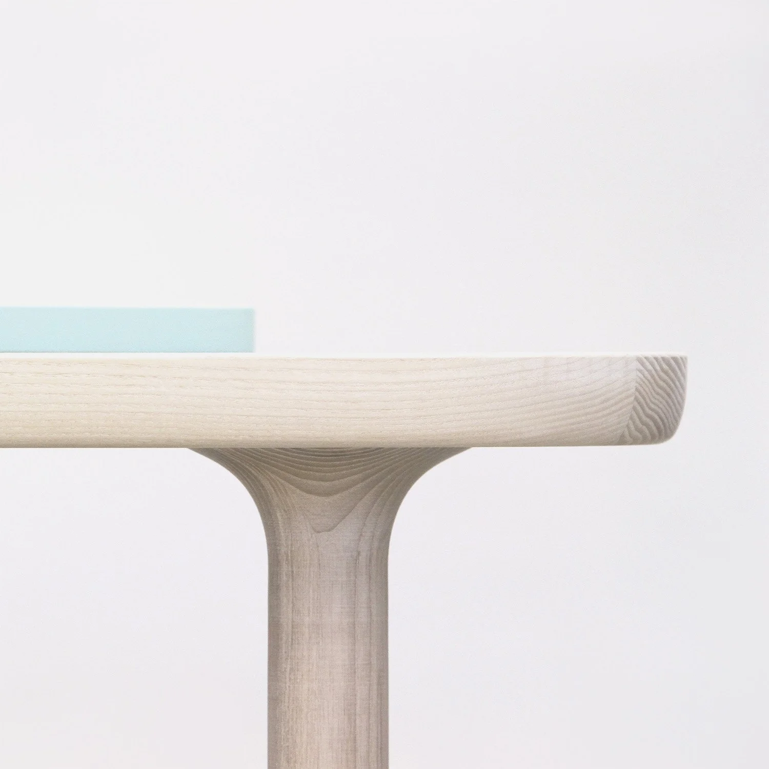 Primer plano del encuentro estructural donde la pata de madera atraviesa el sobre de la mesa de centro KT-1.