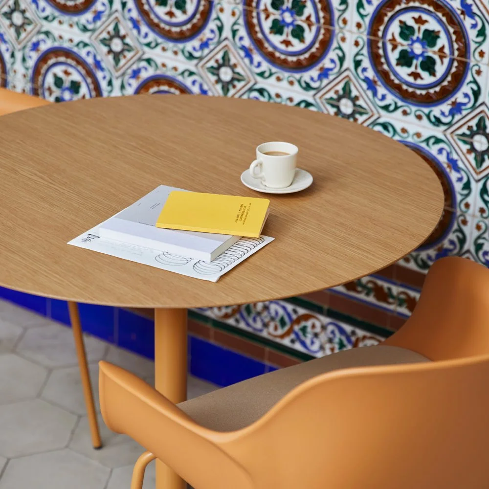 Diseño de escenario para EsPattio con la mesa Bistro en un entorno arquitectónico de alto contraste lumínico.