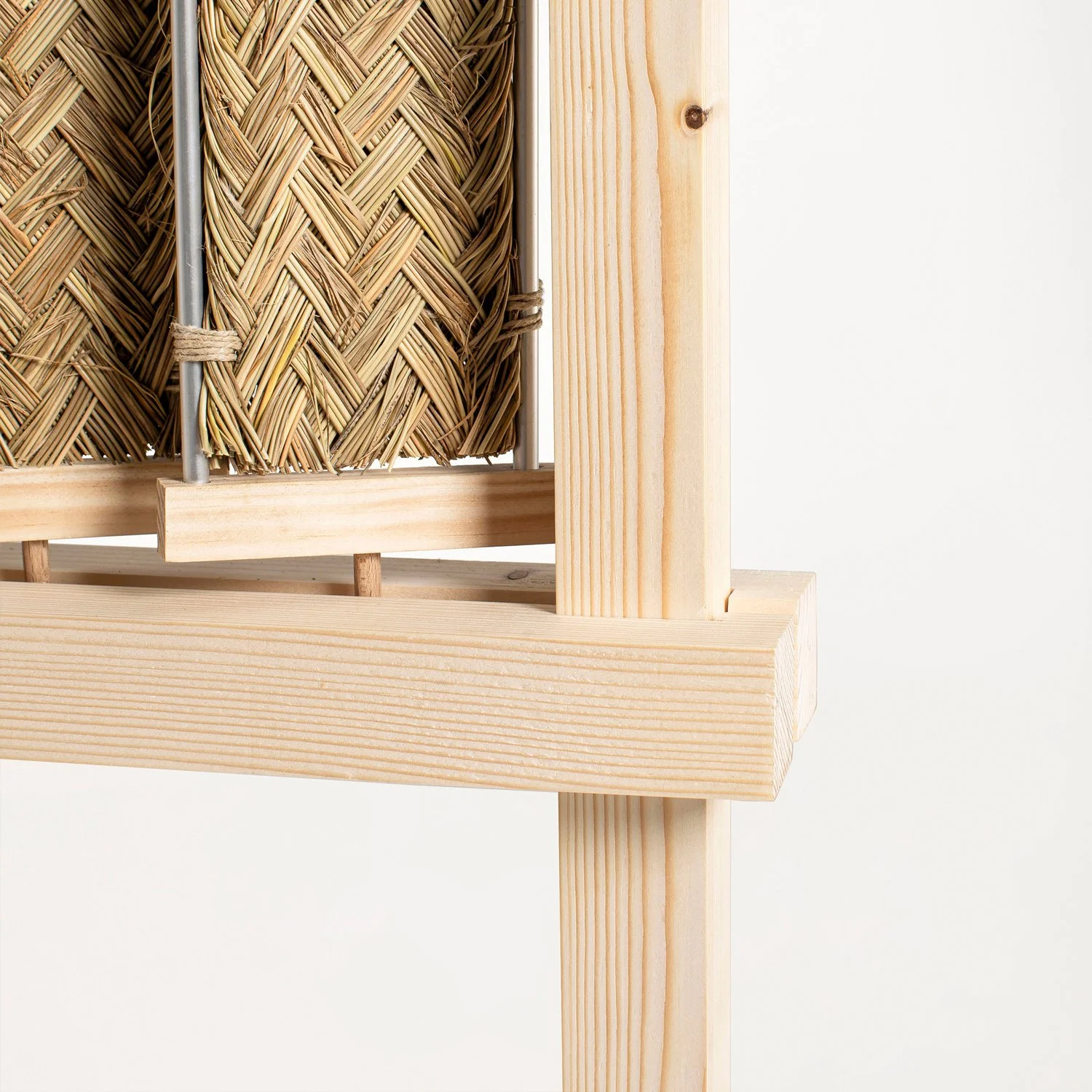 Macro view of the Nür sculptural screen highlighting the contrast between smooth wood and tactile natural fiber.