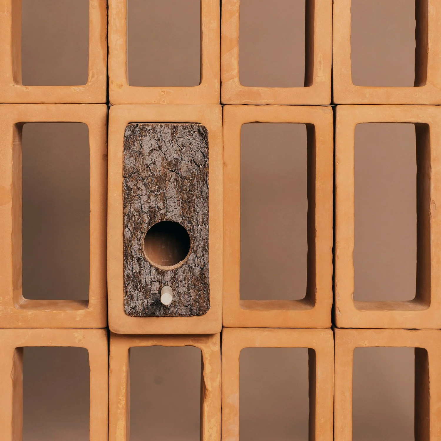 Detailed view of a ceramic lattice installation focusing on the birdhouse module and its seamless integration within the modular grid.