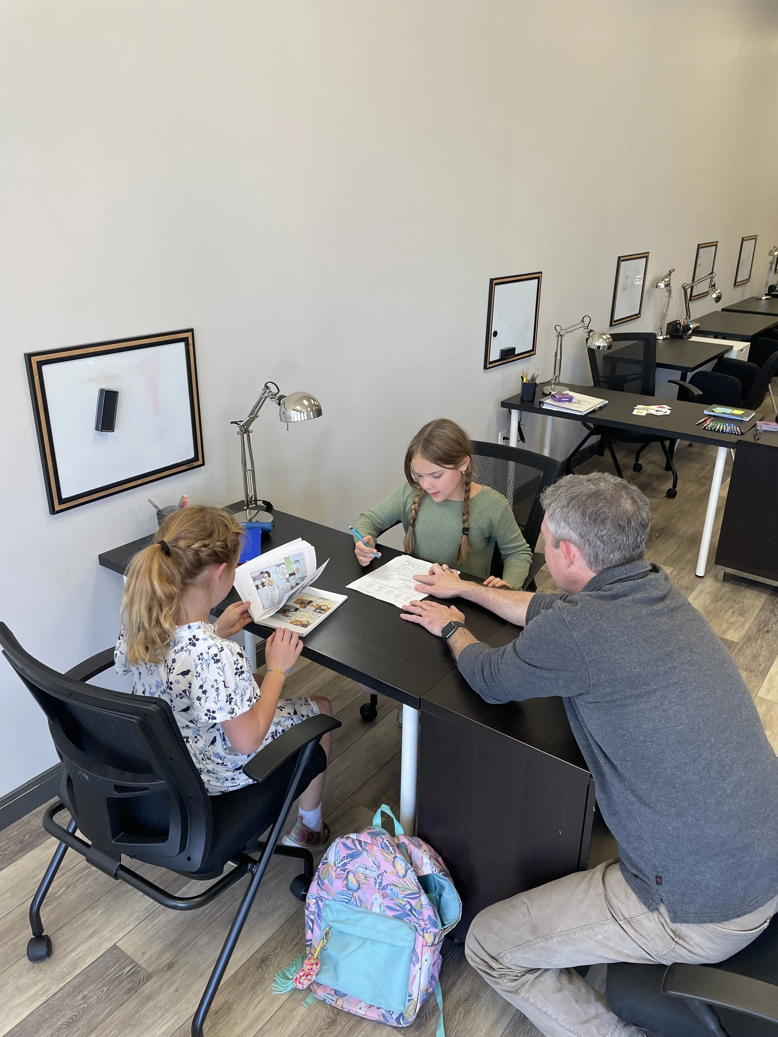 A learning coach provides homework help in a group session of Homework Club.