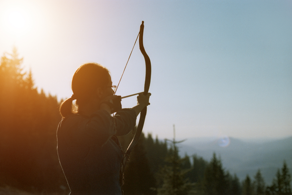 Person drawing bow and arrow at sunset demonstrating focus, mindfulness, and intentional decision-making during divorce