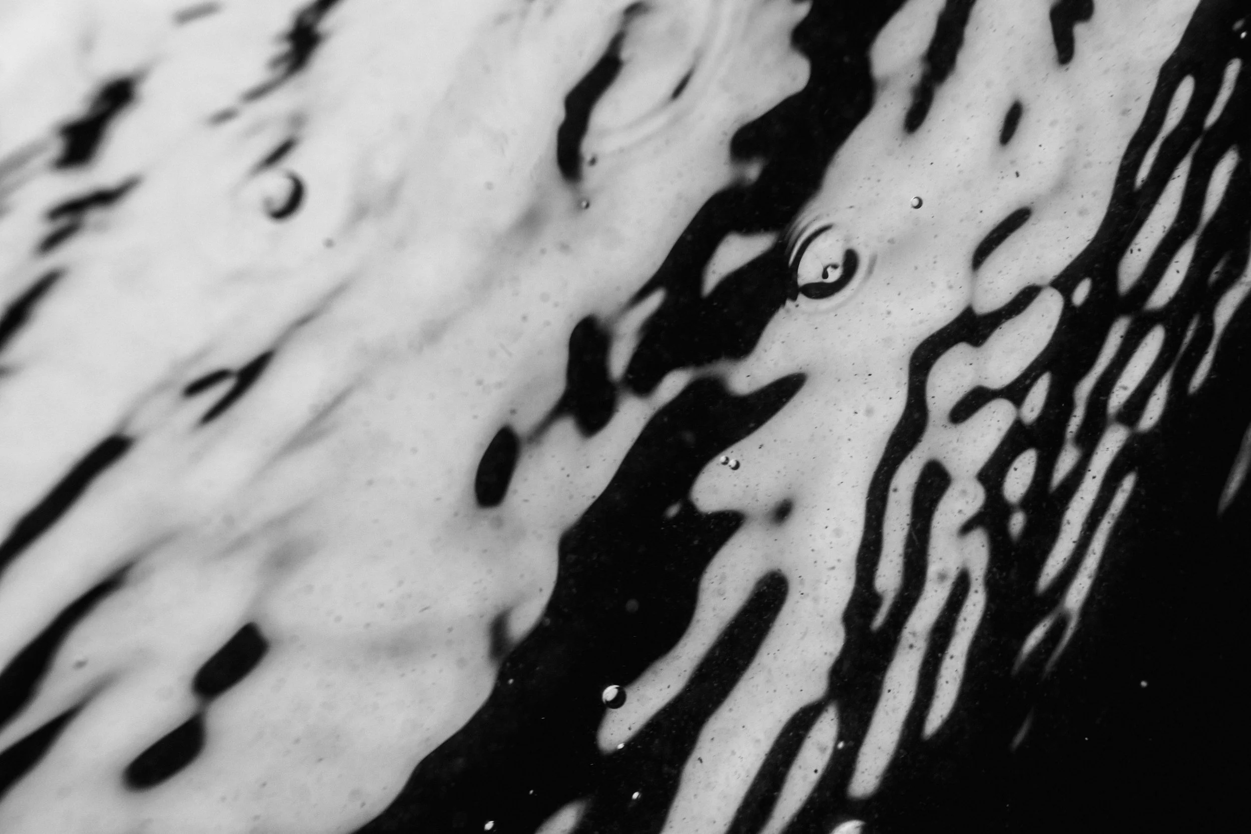 Close-up of a surface with black and white abstract streaks and textures.