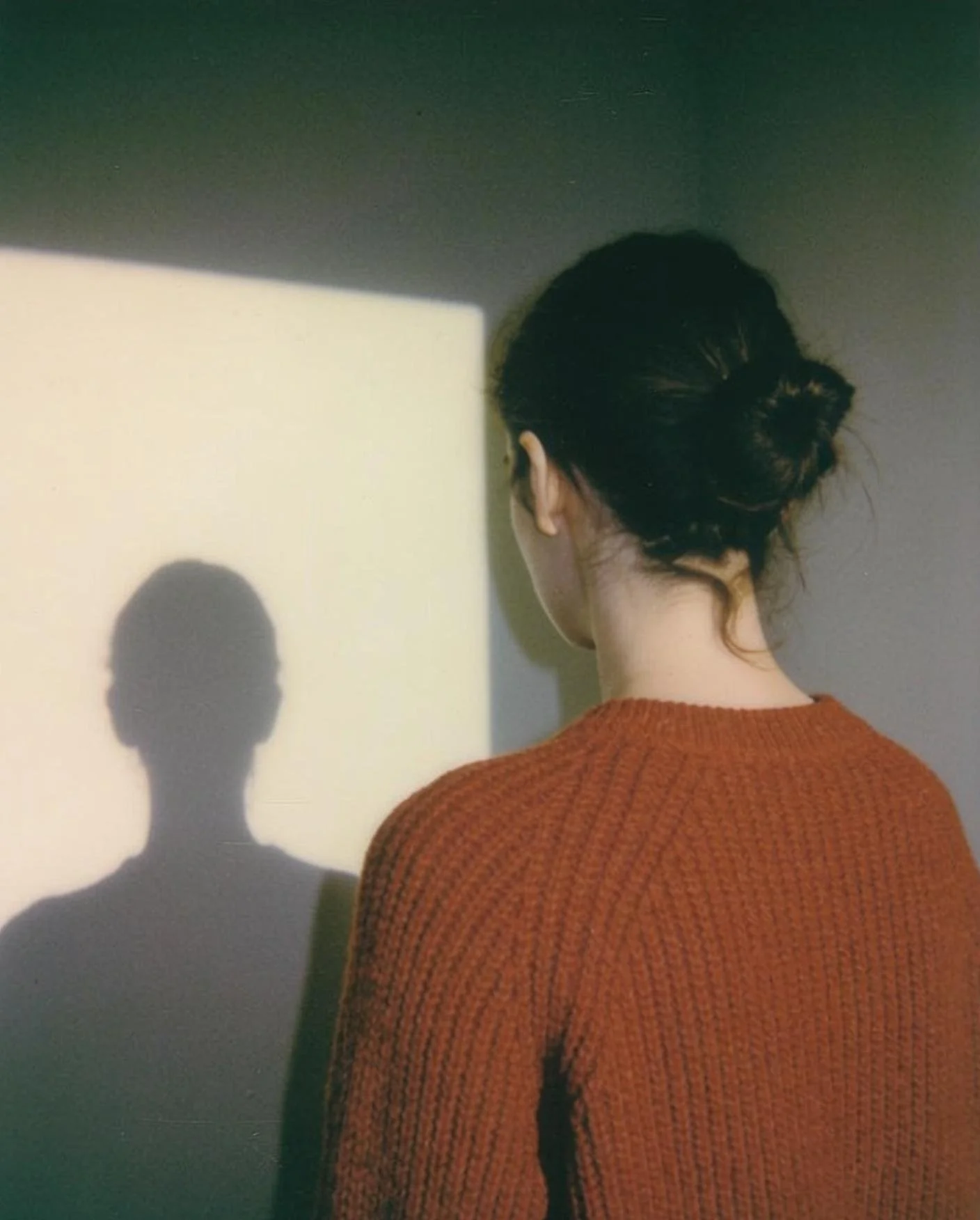 Femme de dos devant un mur clair, aller à la racine de la blessure de rejet
