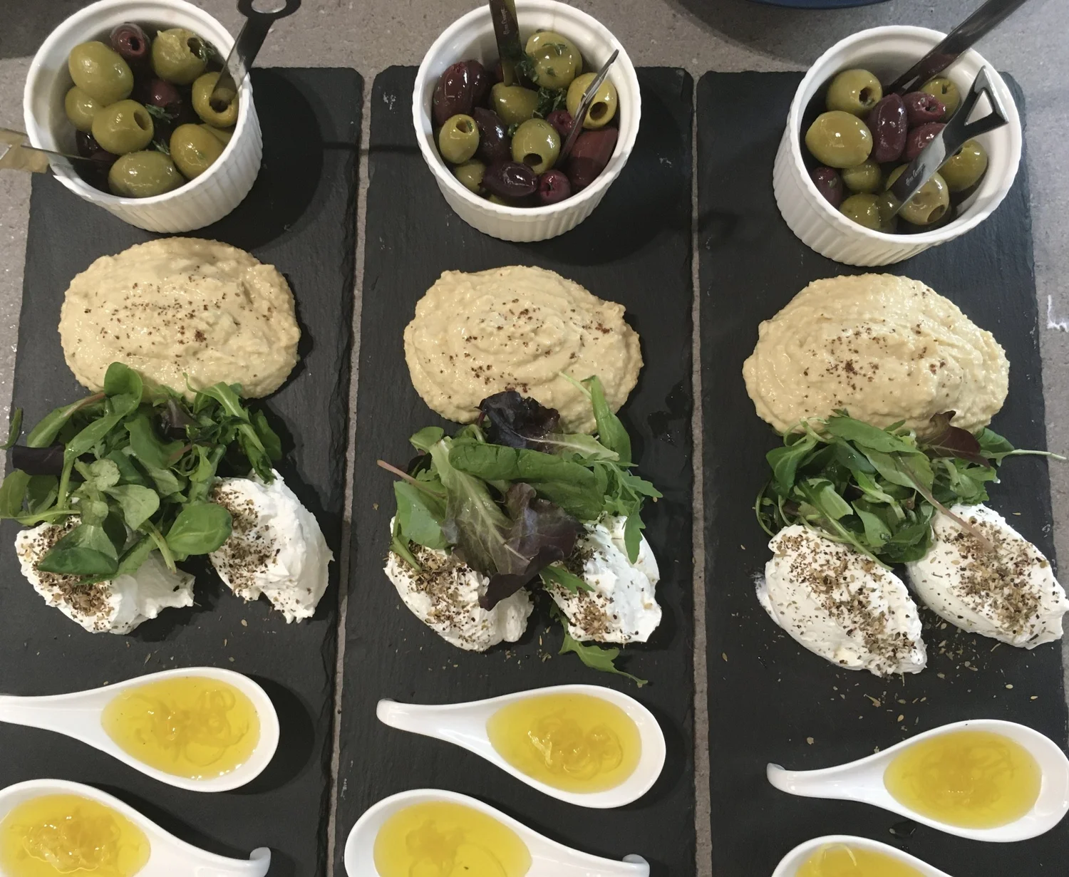 Plates of olives, hummus with paprika and dips.