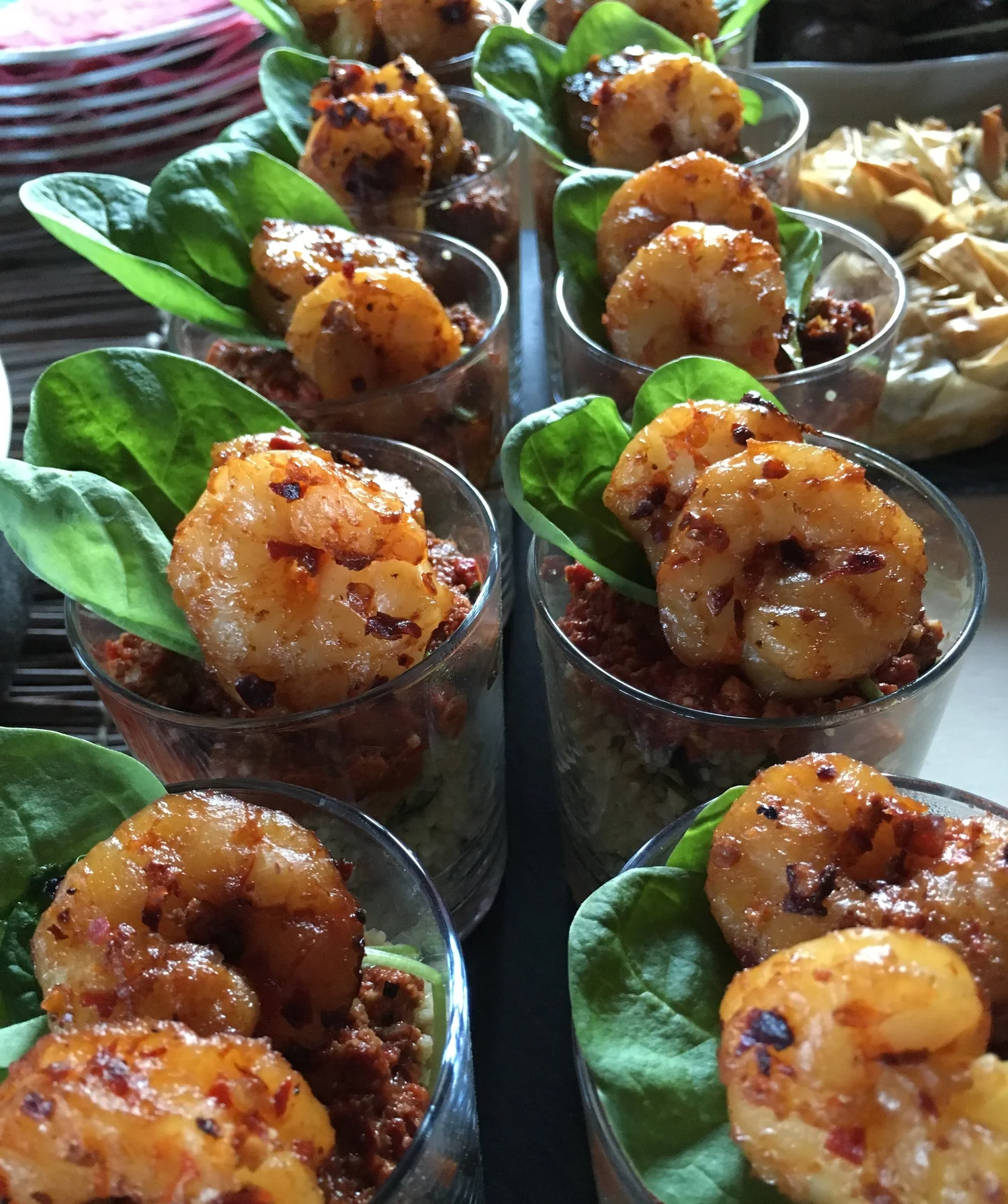 Glass cups of prawns, greens, minced meat and rice.