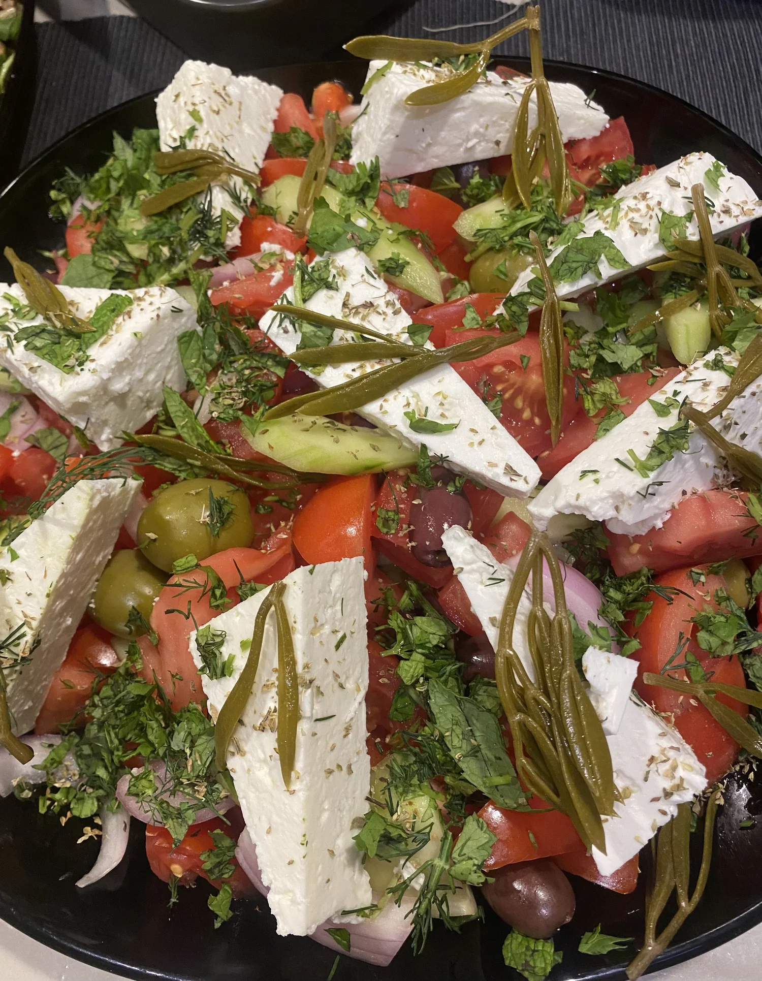 Greek salad with feta, tomato, cucumber, olives and herbs.