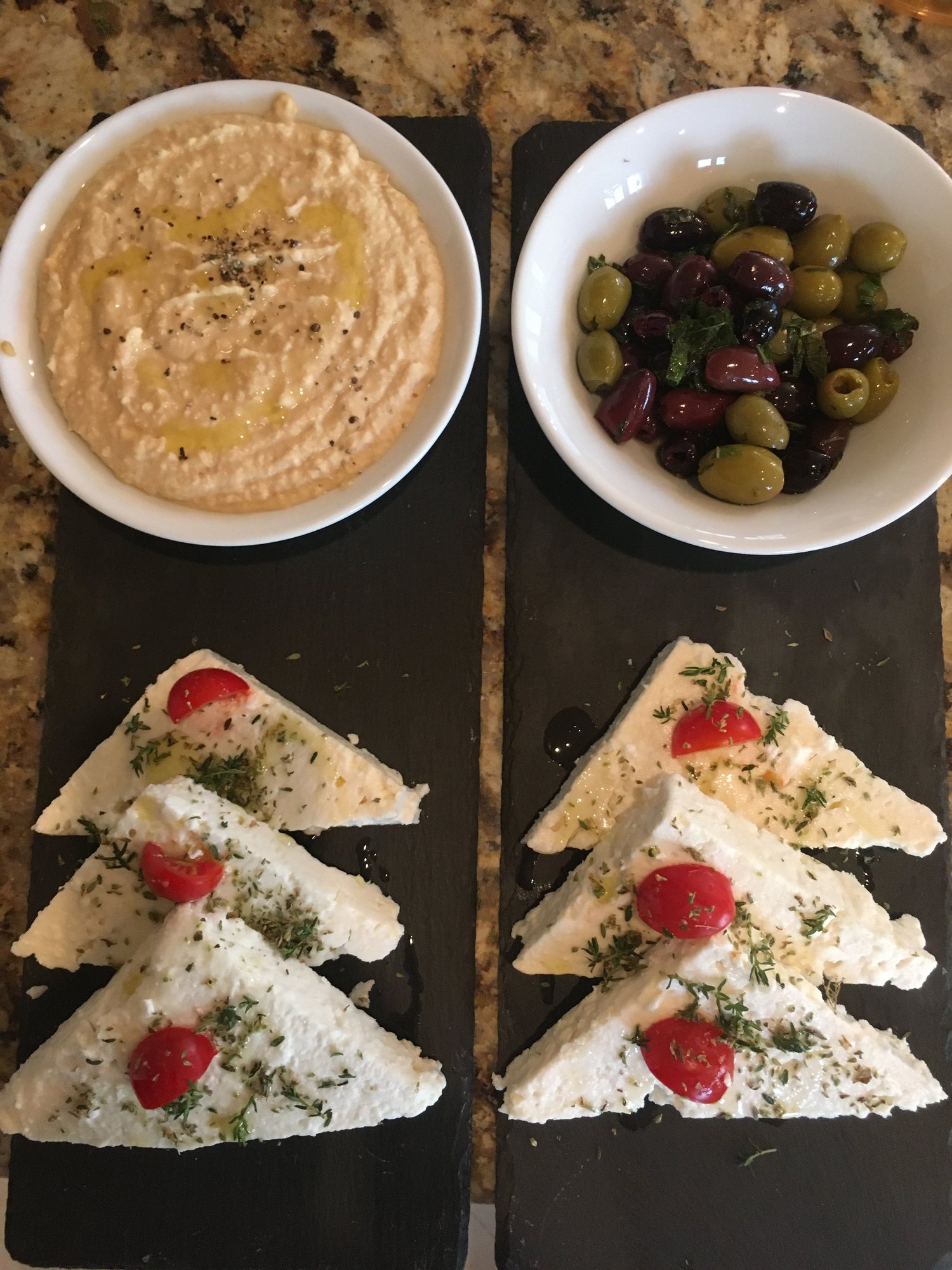 Top-down Mediterranean platter with hummus and accompaniments.