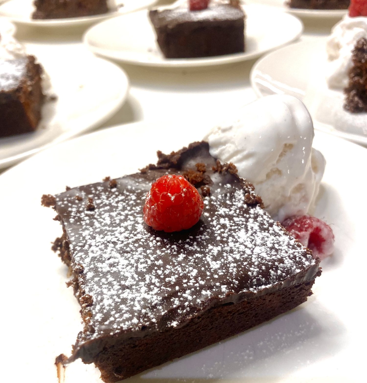 Chocolate brownie with raspberry and powdered sugar.