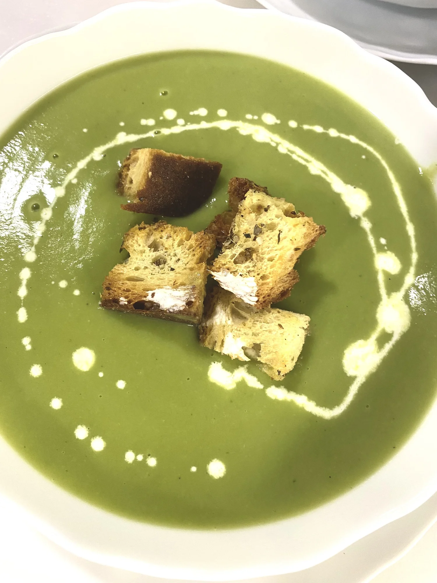 Pea soup with croutons and cream.