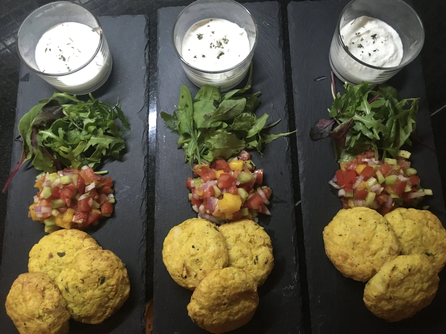 Spicy potato cakes with tomato salsa on slate.