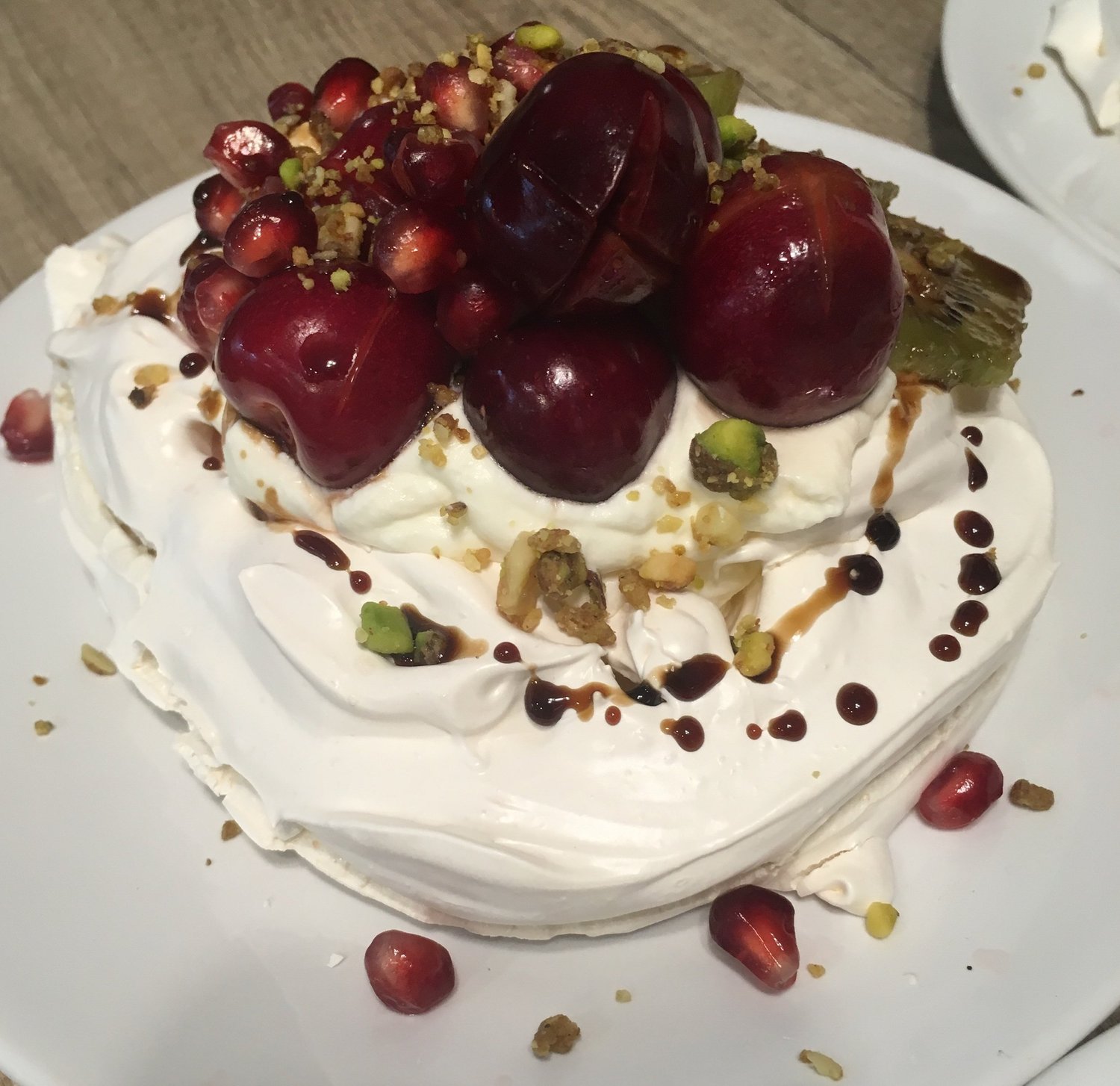 Cherry-topped pavlova with pomegranate and pistachios.