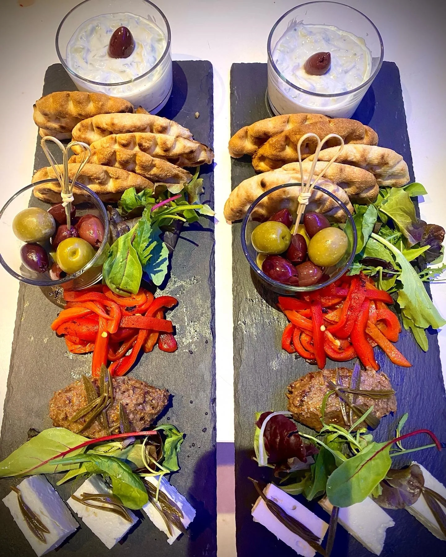 Slate platters of grilled bread, olives and small bites.