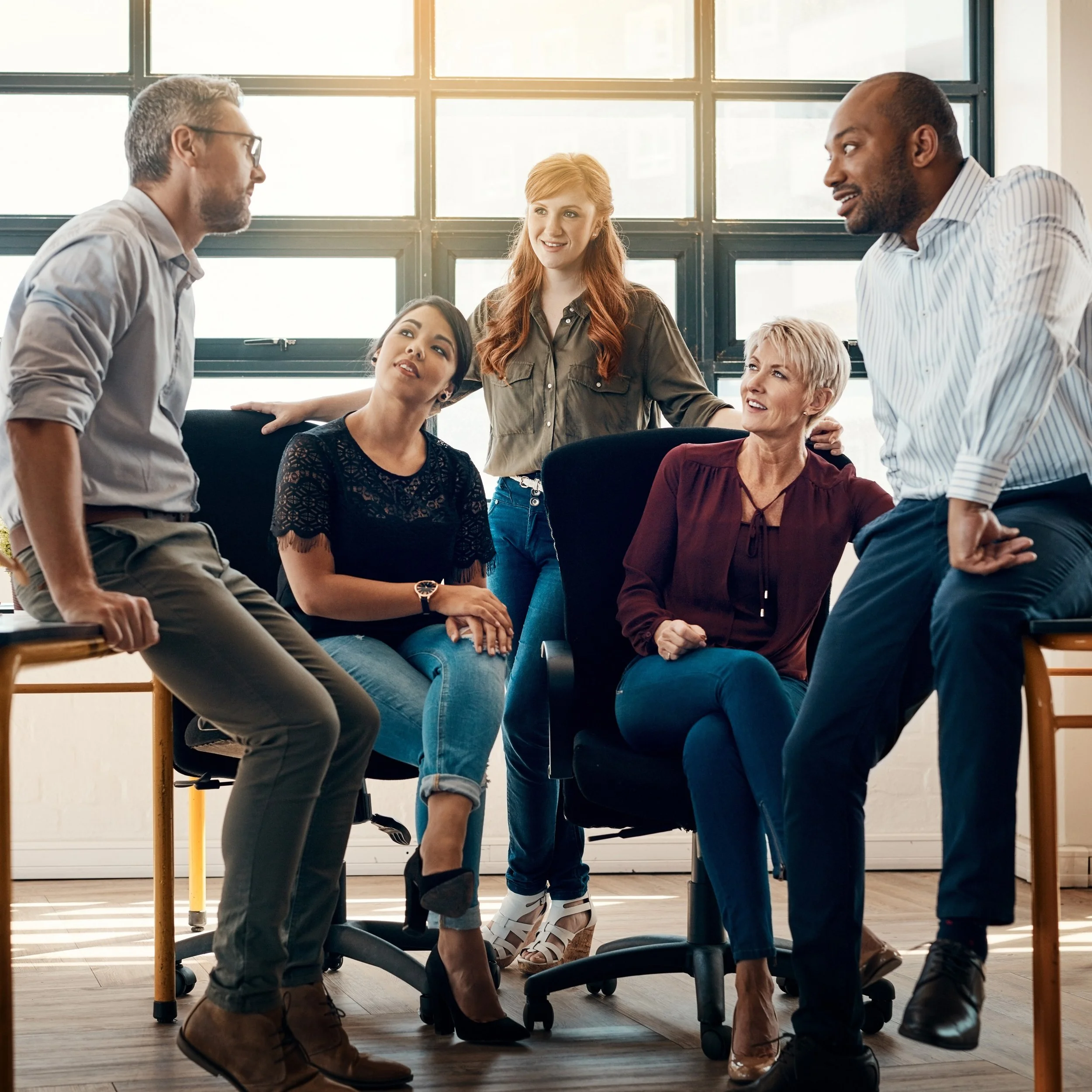 Team of professionals in a facilitated strategy session, actively listening and discussing priorities to align on goals and commitments.