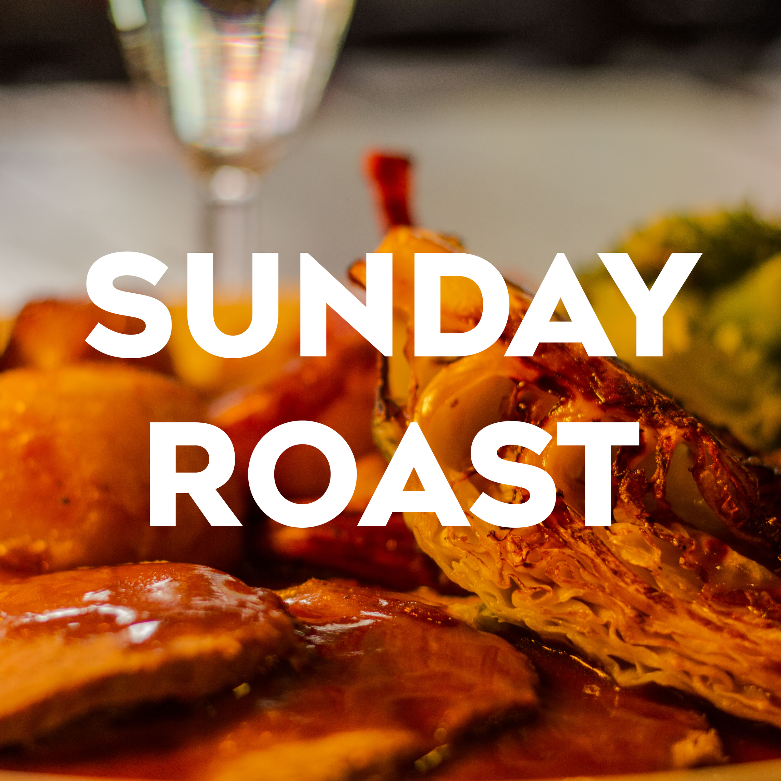 Close-up of cooked meat and vegetables on a plate with a glass of water in the background, with the word 'SUNDAY' partially visible over the image.