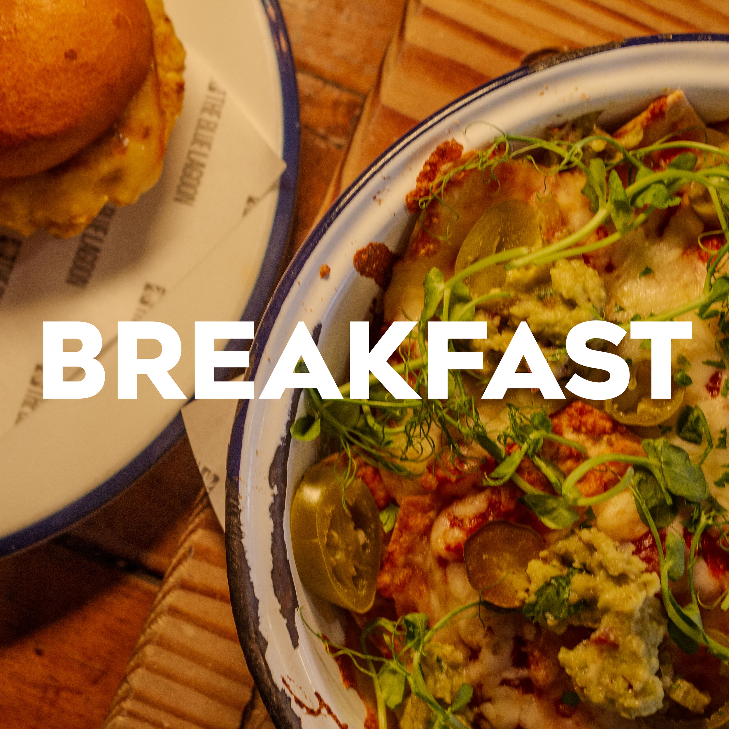 Close-up of a breakfast meal with various food items on a plate, partially visible, with 'BREAKFAST' text overlaying the image.