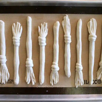 Place broomsticks on a baking sheet 1" apart