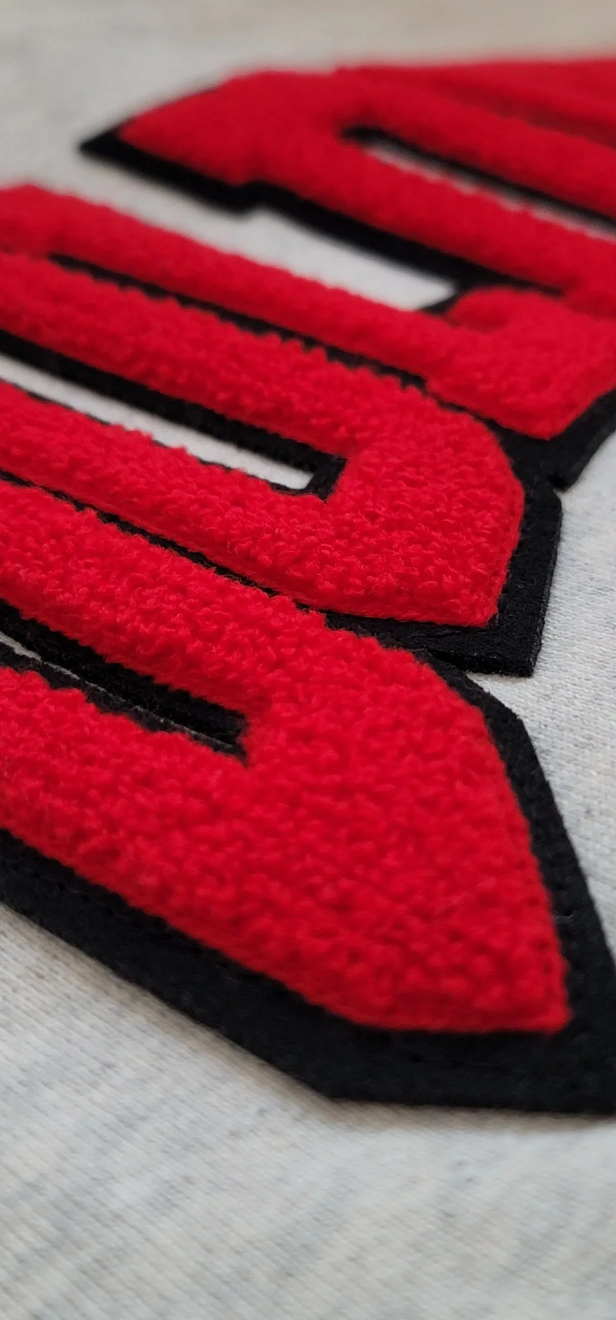 Close-up of red chenille lettering with black outline