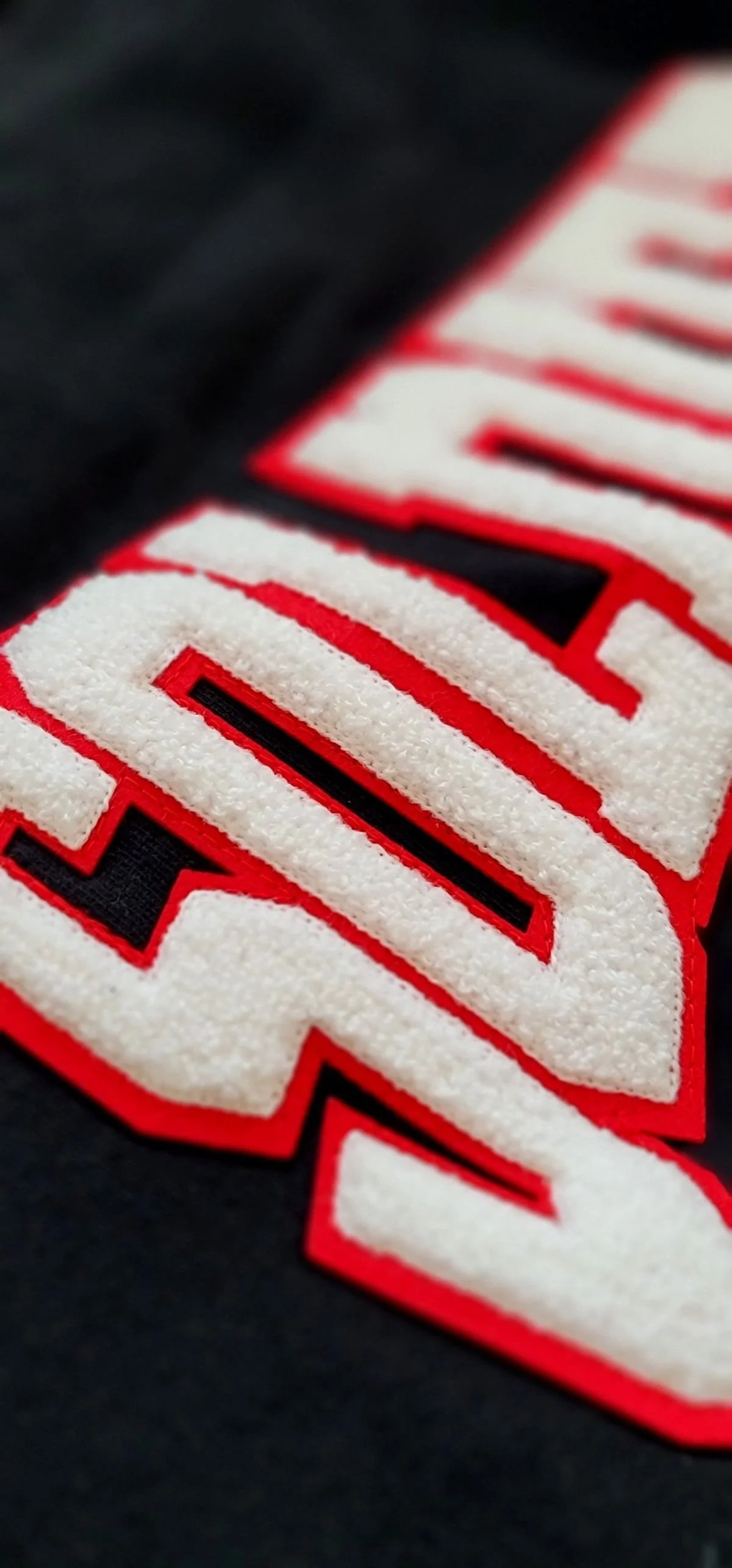 Close-up of white and red chenille SOLDIER lettering