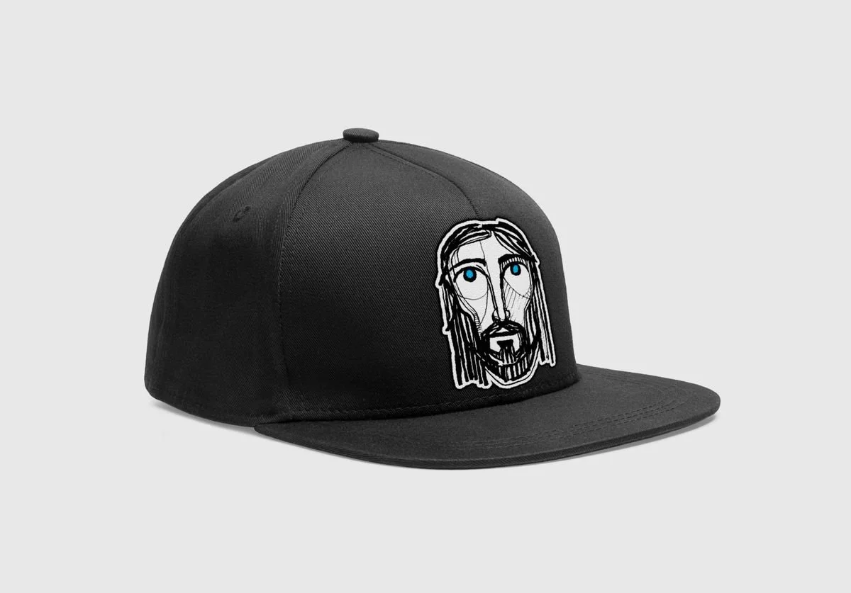 Black snapback with an illustrated face of Jesus patch