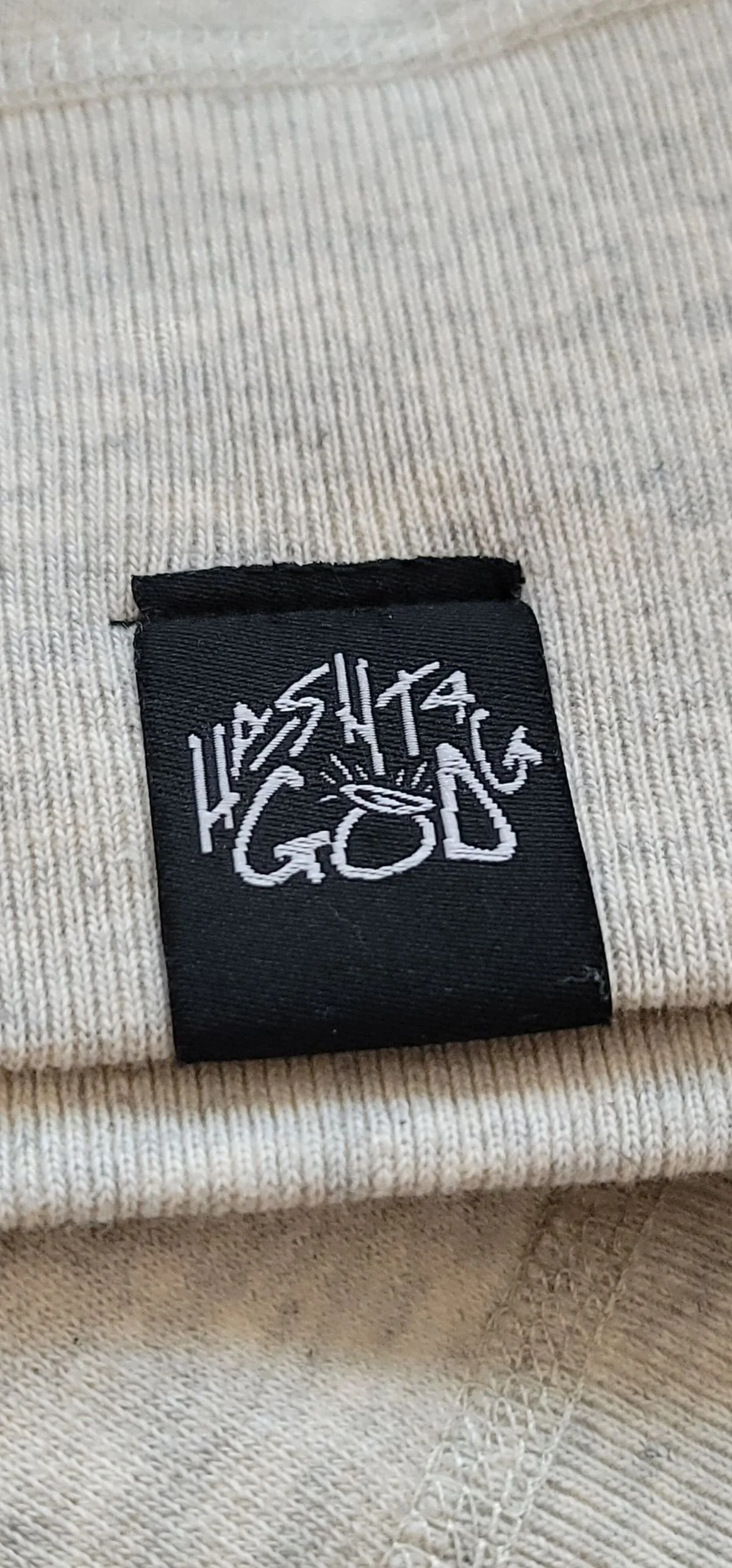 Black woven Hashtag God label with halo logo