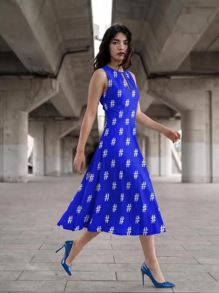 A woman walking in a blue # print dress