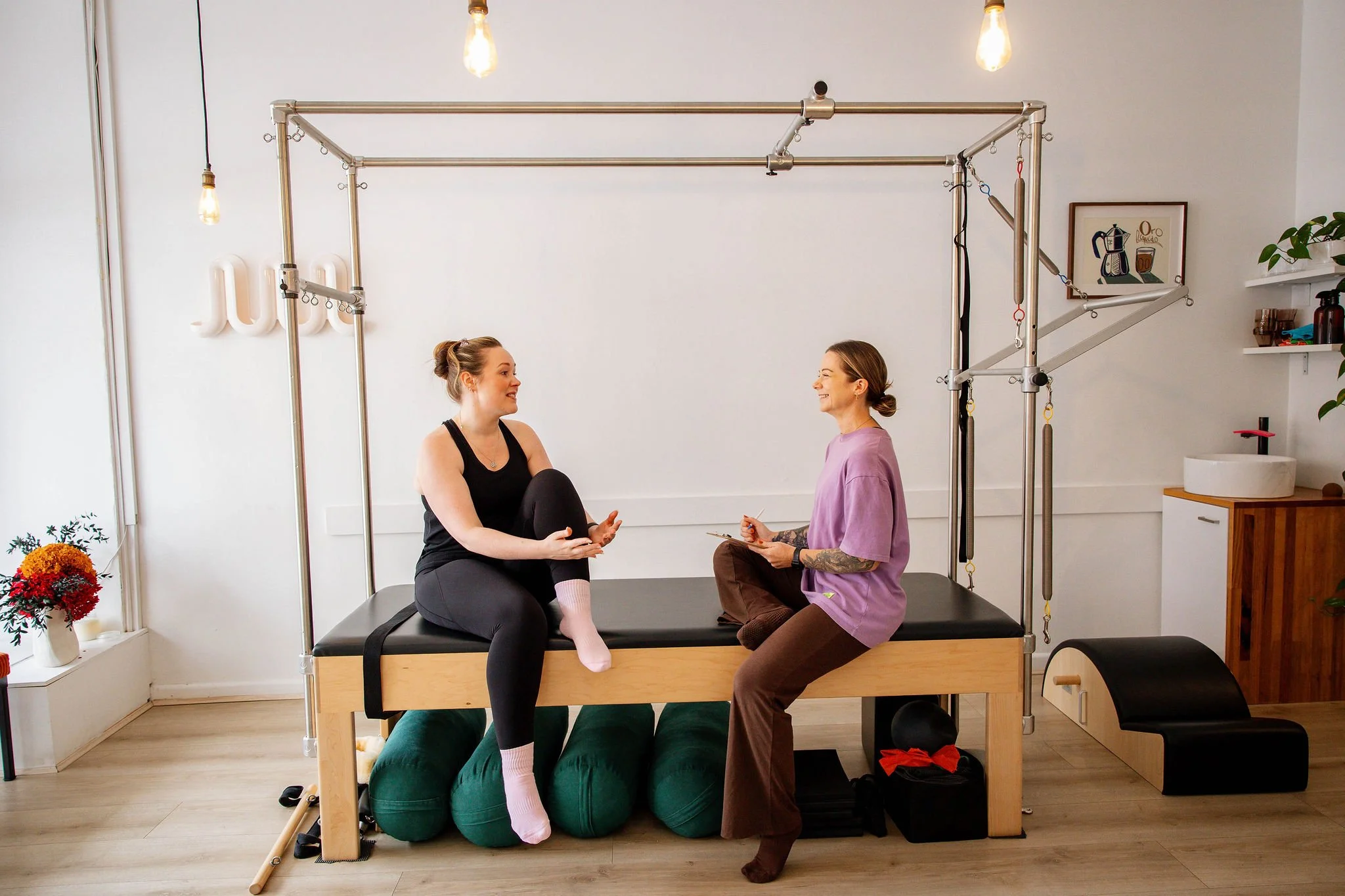 Instructor and client in unhurried conversation at Rosy Movement's size-inclusive Pilates studio, Collingwood Melbourne