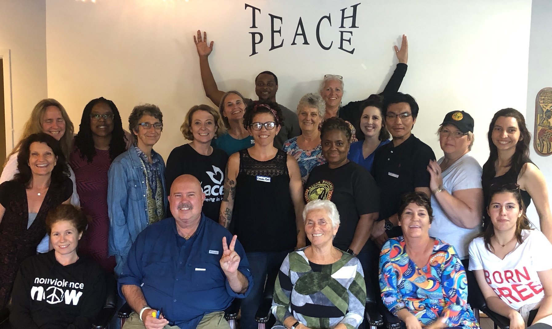 RPCP team and participants gathered under 'TEACH PEACE' sign