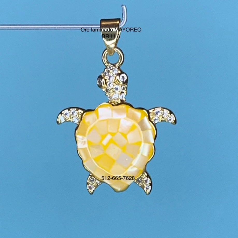 Dije de tortuga amarilla en oro laminado con concha brillante. Yellow turtle pendant in laminated gold with radiant shell.