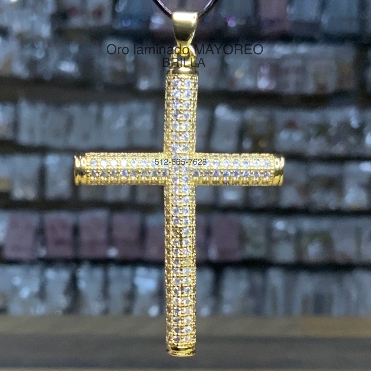 Cruz tubular en oro laminado con incrustaciones. Tubular laminated gold cross with stones.