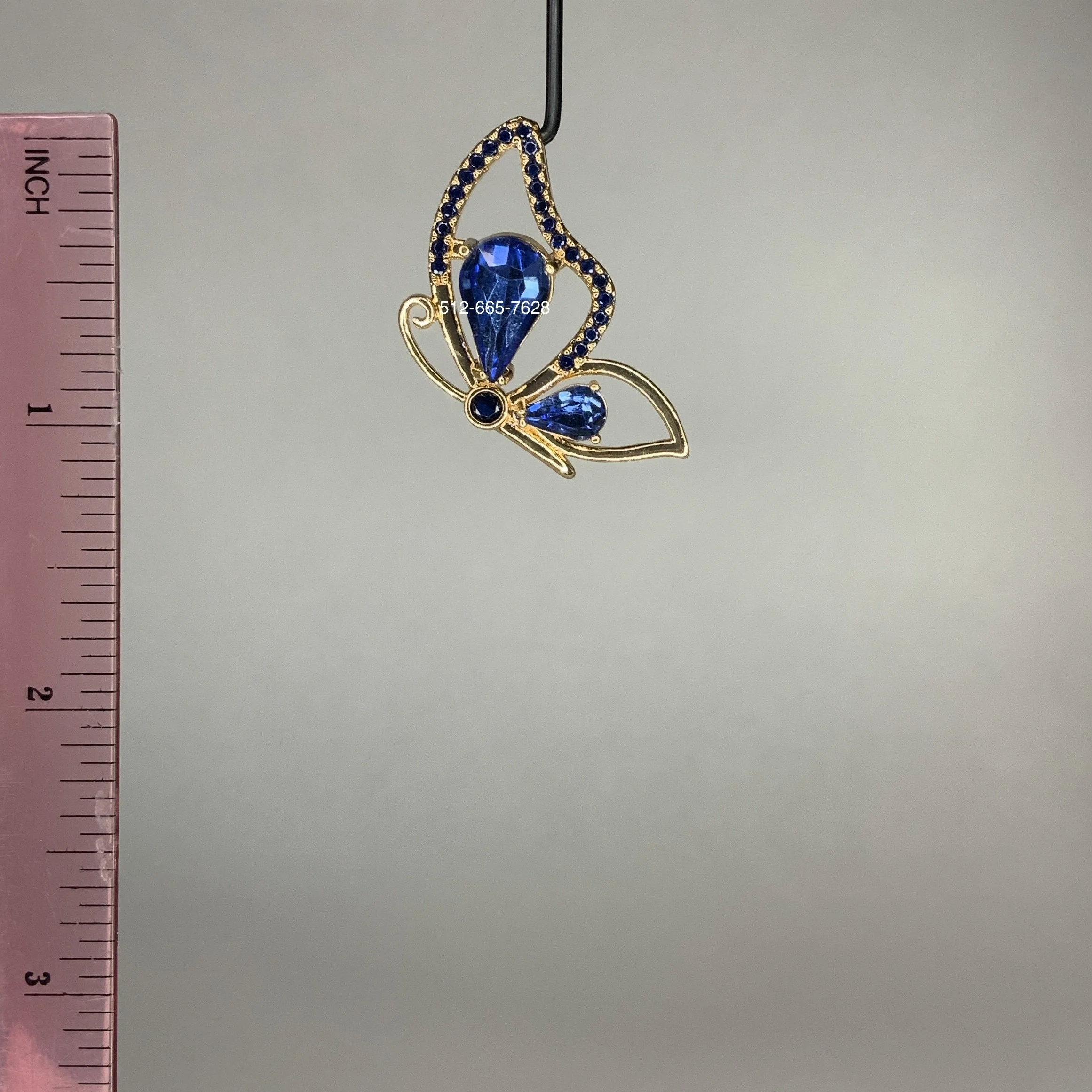 Dije mariposa laminada en oro con piedras azul rey. Gold plated butterfly pendant with royal blue stones.