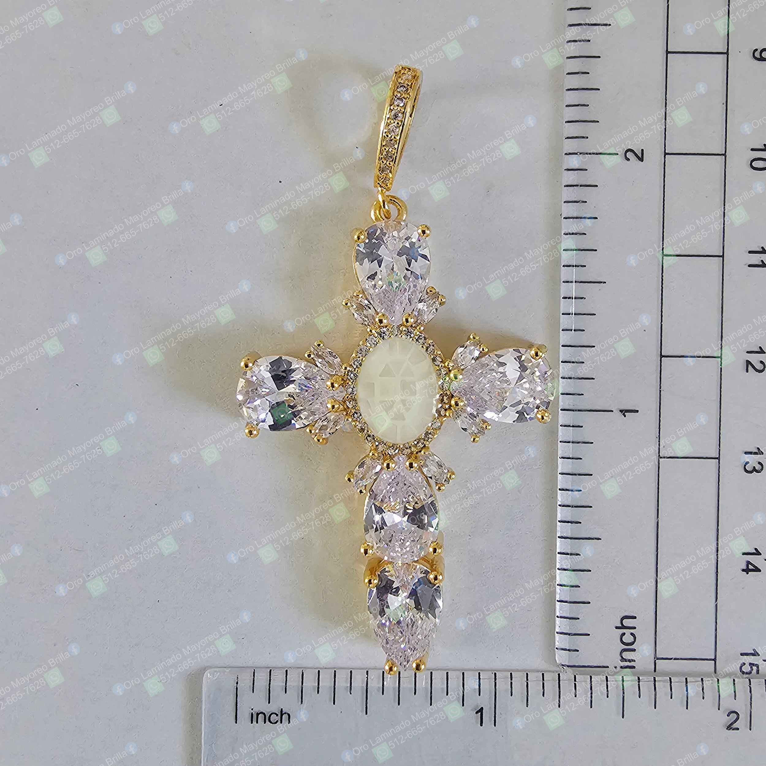 Dije cruz color oro con piedras decorativas visibles y diseño facetado | Gold color cross pendant with visible decorative stones and faceted design