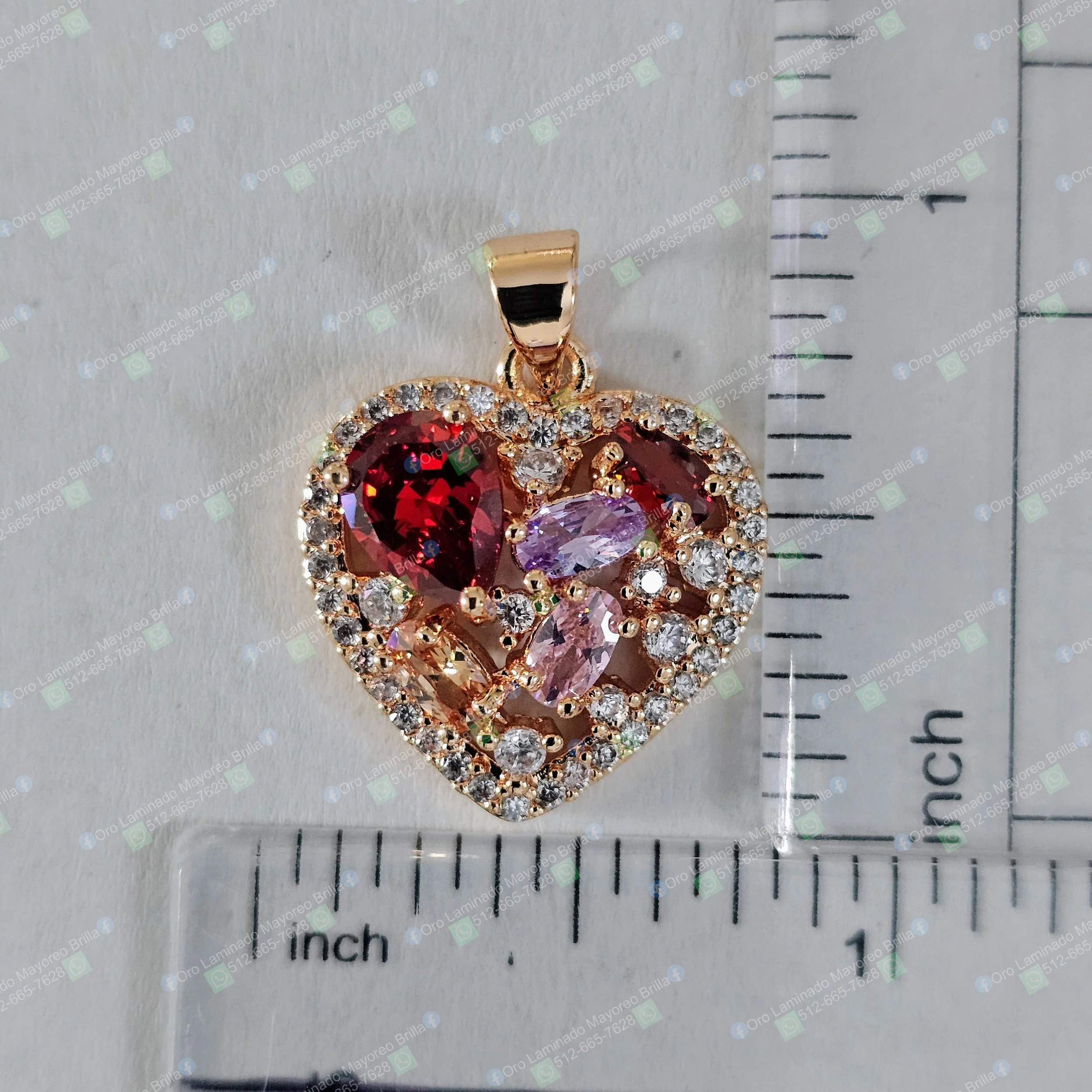 Dije de corazon color oro con piedras decorativas en varios colores visibles | Gold color heart pendant with visible decorative stones in various colors