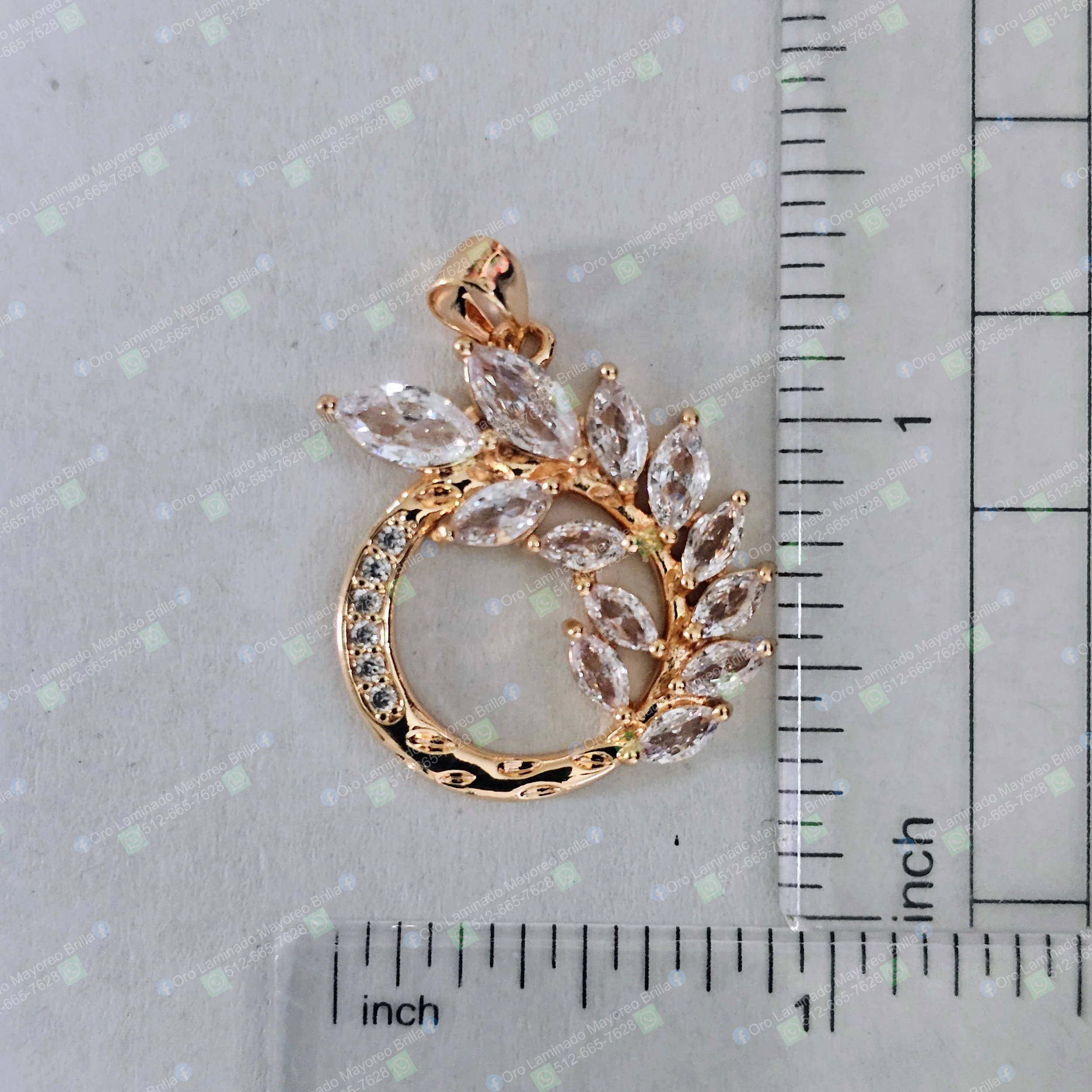 Dije circular con rama y hojas color oro con piedras decorativas visibles | Gold color circular pendant with branch and leaves with visible decorative stones