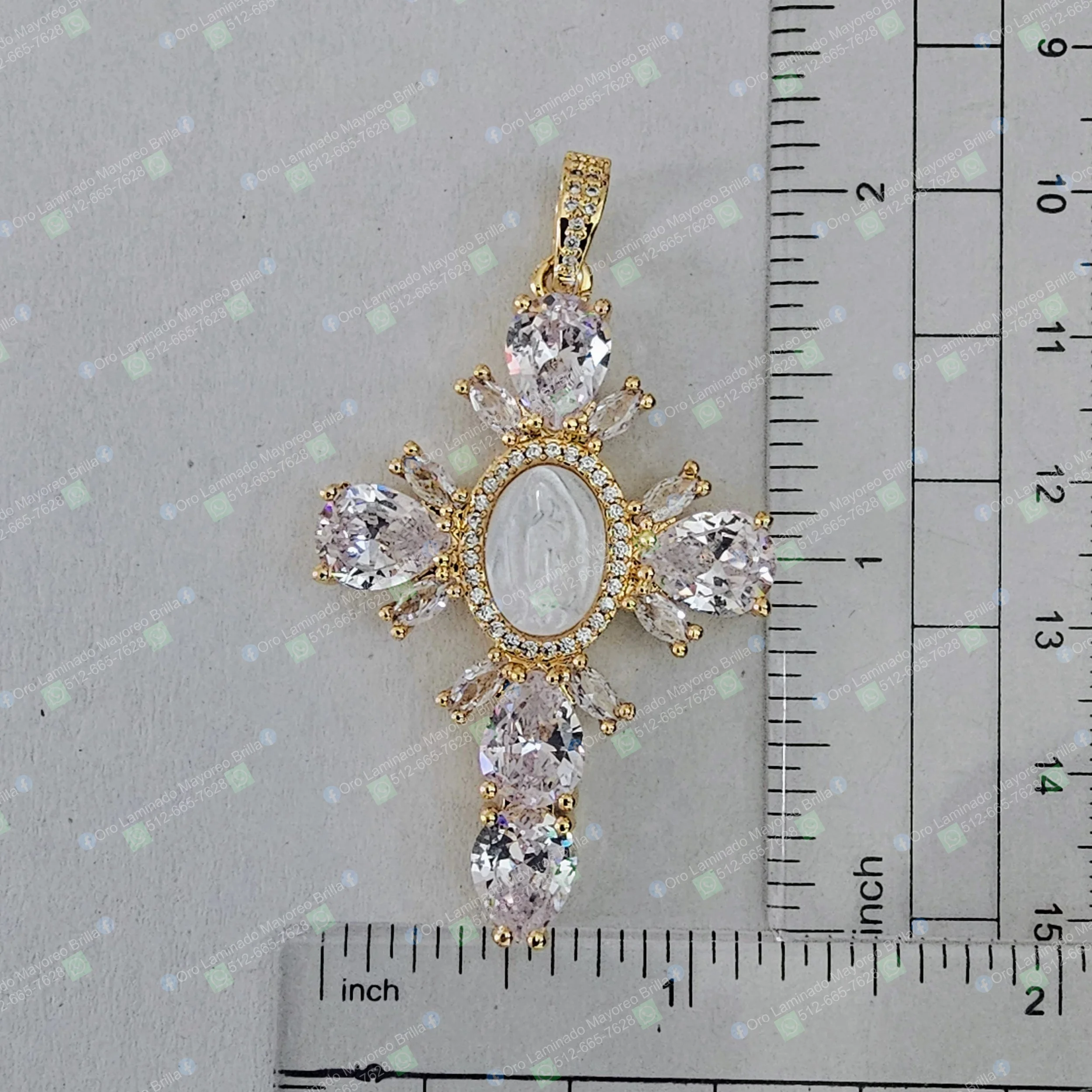 Dije cruz color oro con Virgen en el centro y piedras decorativas visibles | Gold color cross pendant with Virgin in center and visible decorative stones