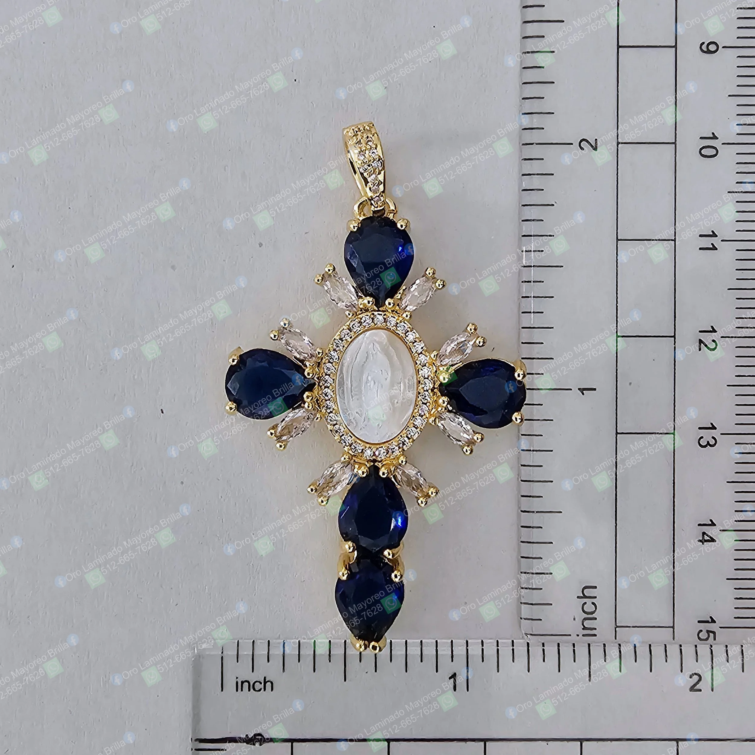 Dije cruz color oro con piedras decorativas azules y transparentes en forma de lágrima y marquise | Gold color cross pendant with blue and clear decorative stones in teardrop and marquise shapes