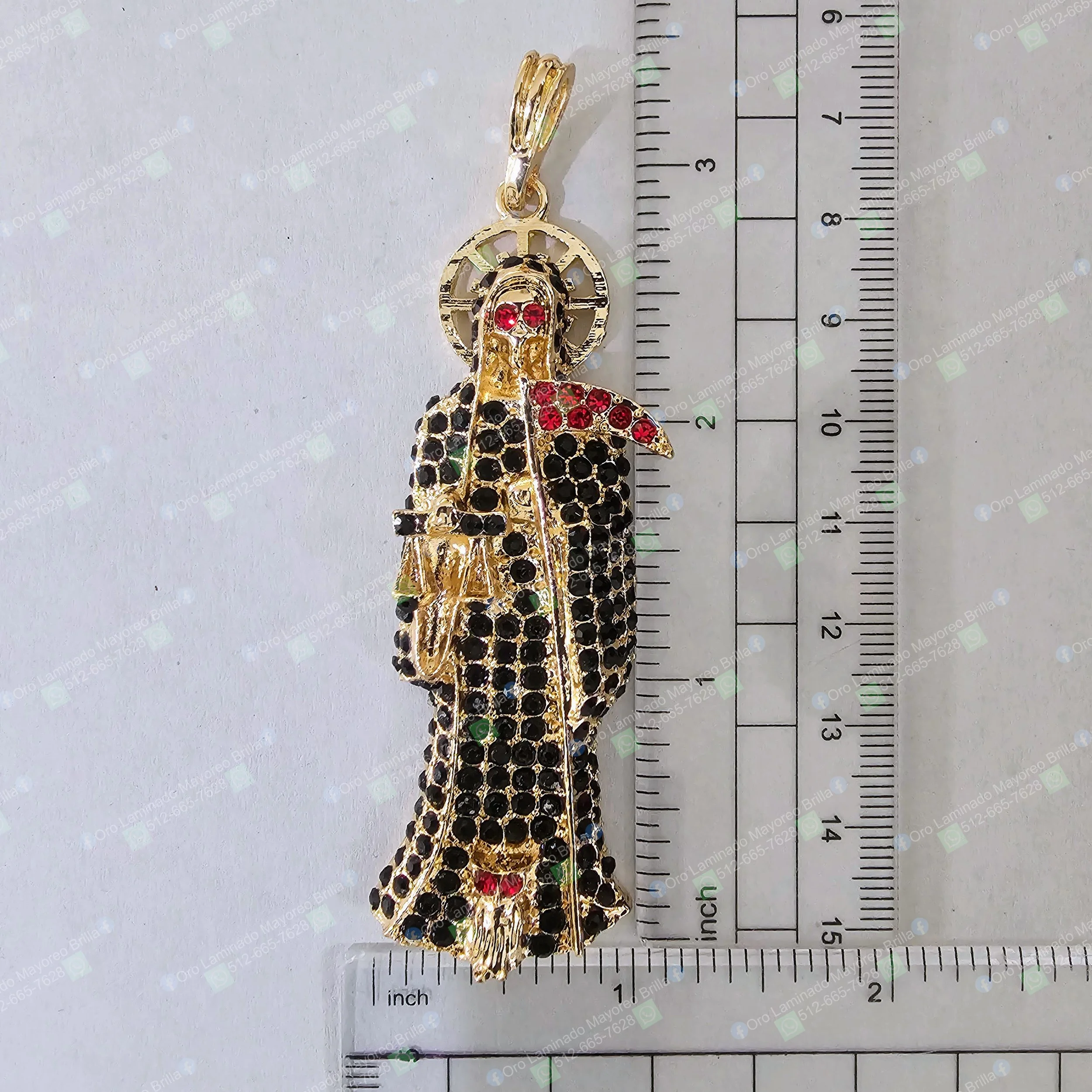 Dije Santa Muerte color oro con piedras decorativas visibles negras y rojas | Gold color Santa Muerte pendant with visible black and red decorative stones