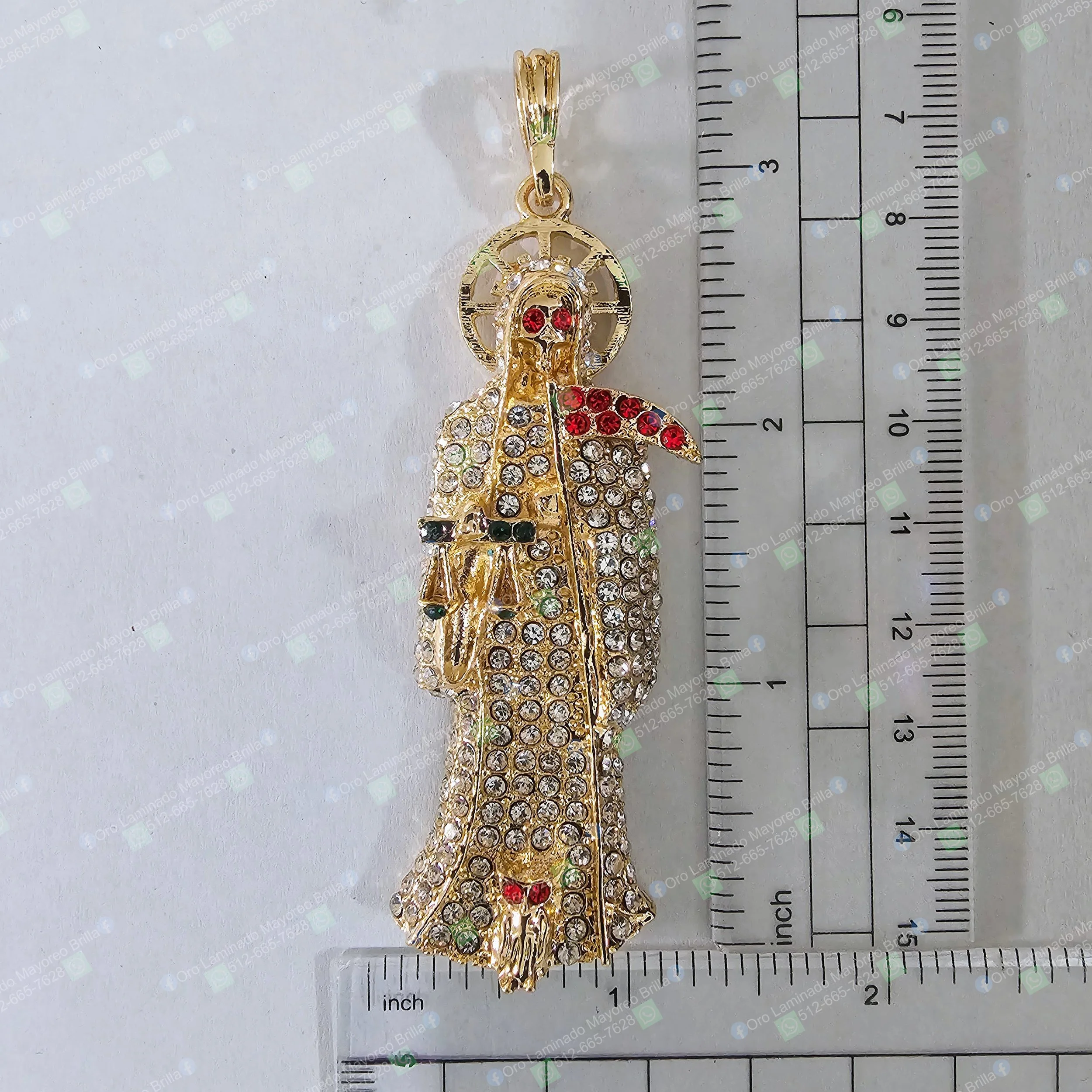 Dije Santa Muerte color oro con piedras decorativas visibles en vestido y detalles rojos y verdes | Gold color Santa Muerte pendant with visible decorative stones and red and green details