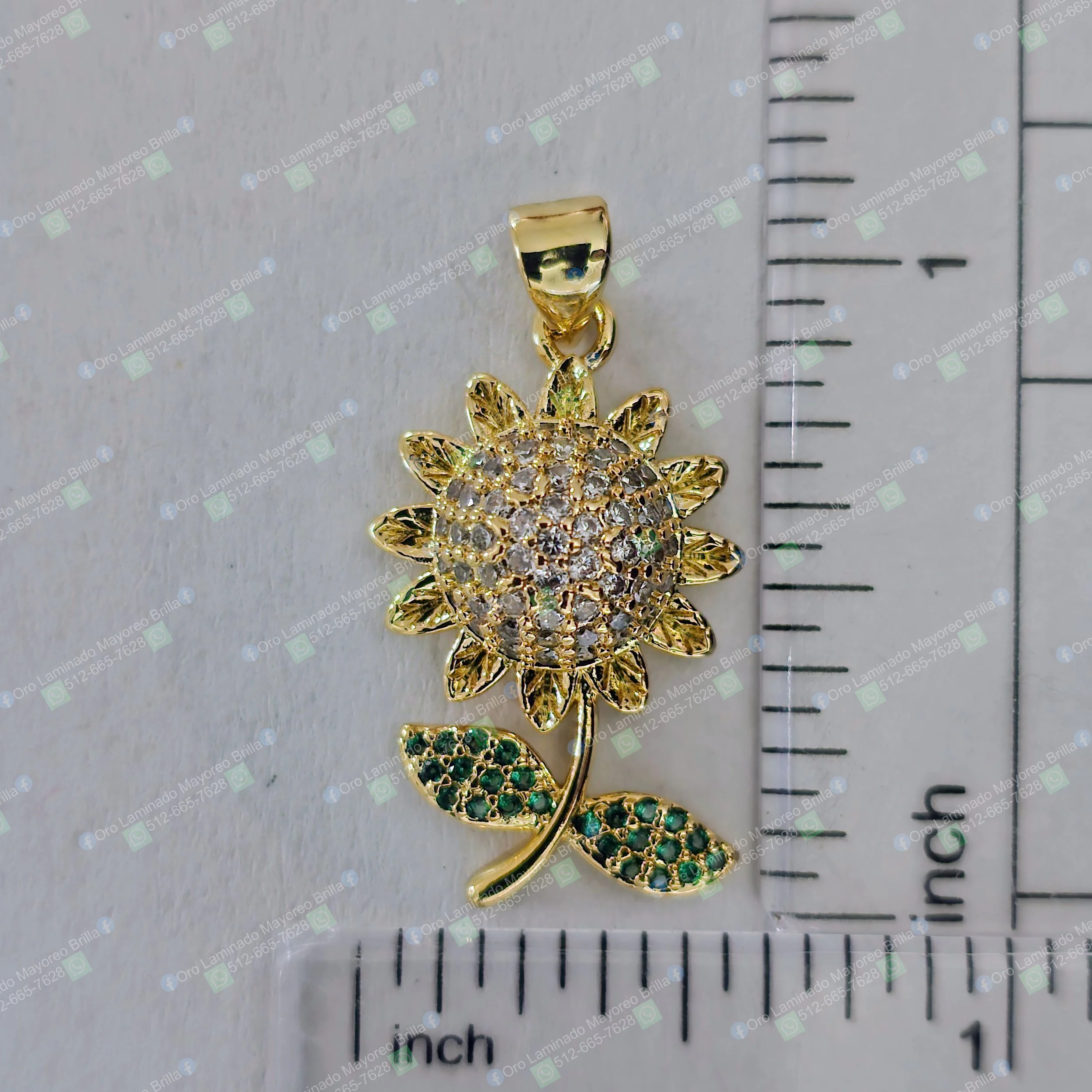 Dije girasol color oro con piedras decorativas claras y verdes en pétalos y hojas | Gold color sunflower pendant with clear and green decorative stones on petals and leaves